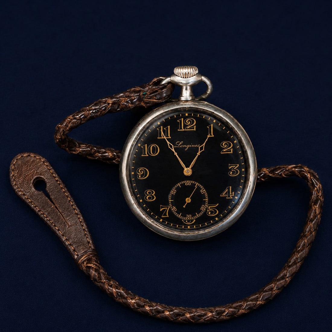 Longines Grand Prix silver pocket watch, Swiss School, 20th century: Silver and enamel. Dimensions: 7 x 4 x 1.5 cm. Longines pocket watch with a black dial and high-contrast gold numerals, accompanied by a braided leather chain. The design combines elegance and functio