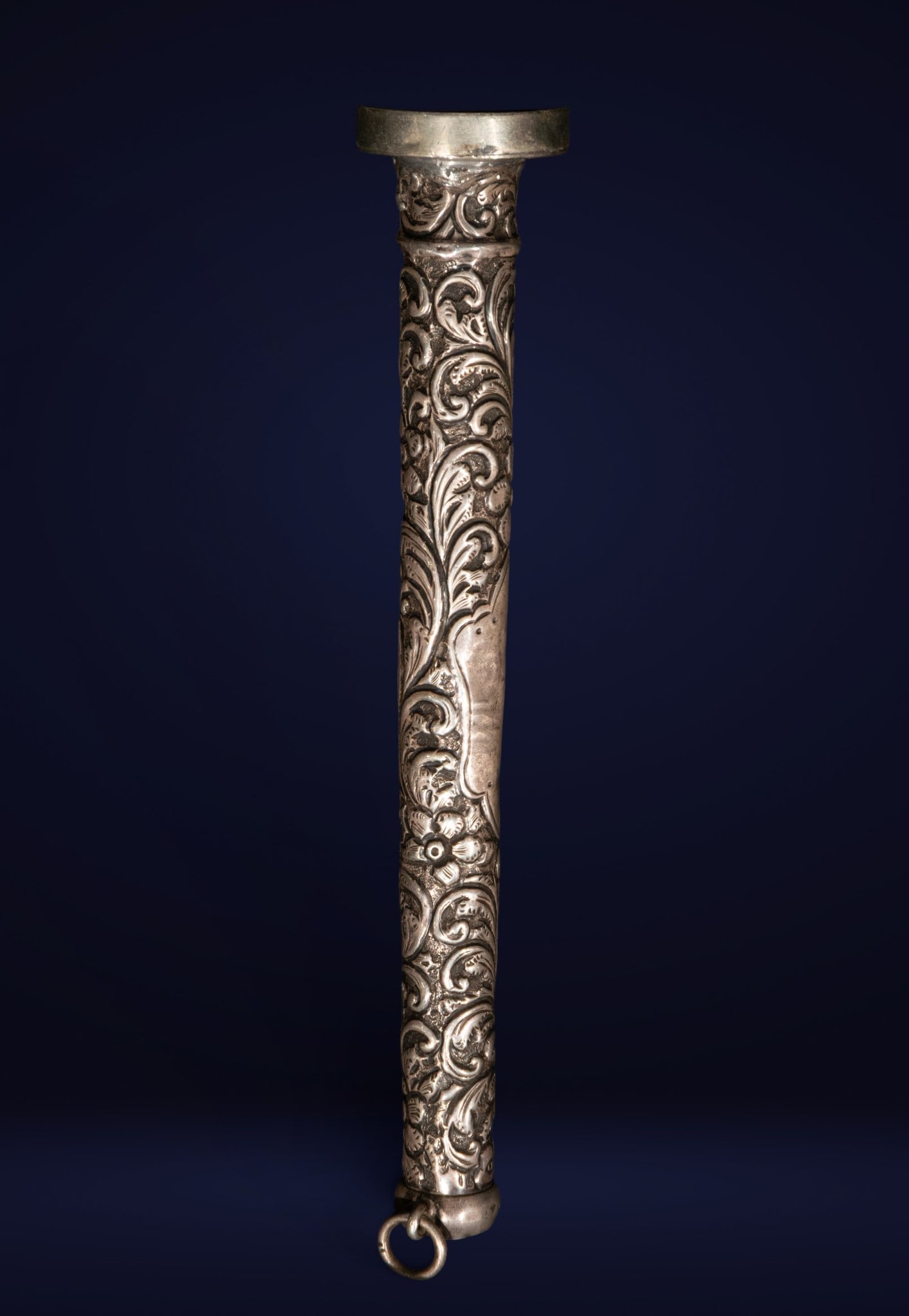 Silver cane handle, European School, 19th Century: Repoussé and chased silver. Dimensions: 20 x 3 x 3 cm. An elegant, tubular cane handle completely decorated with rocaille-inspired floral motifs in relief, featuring sinuous scrolls, flowers, and lea