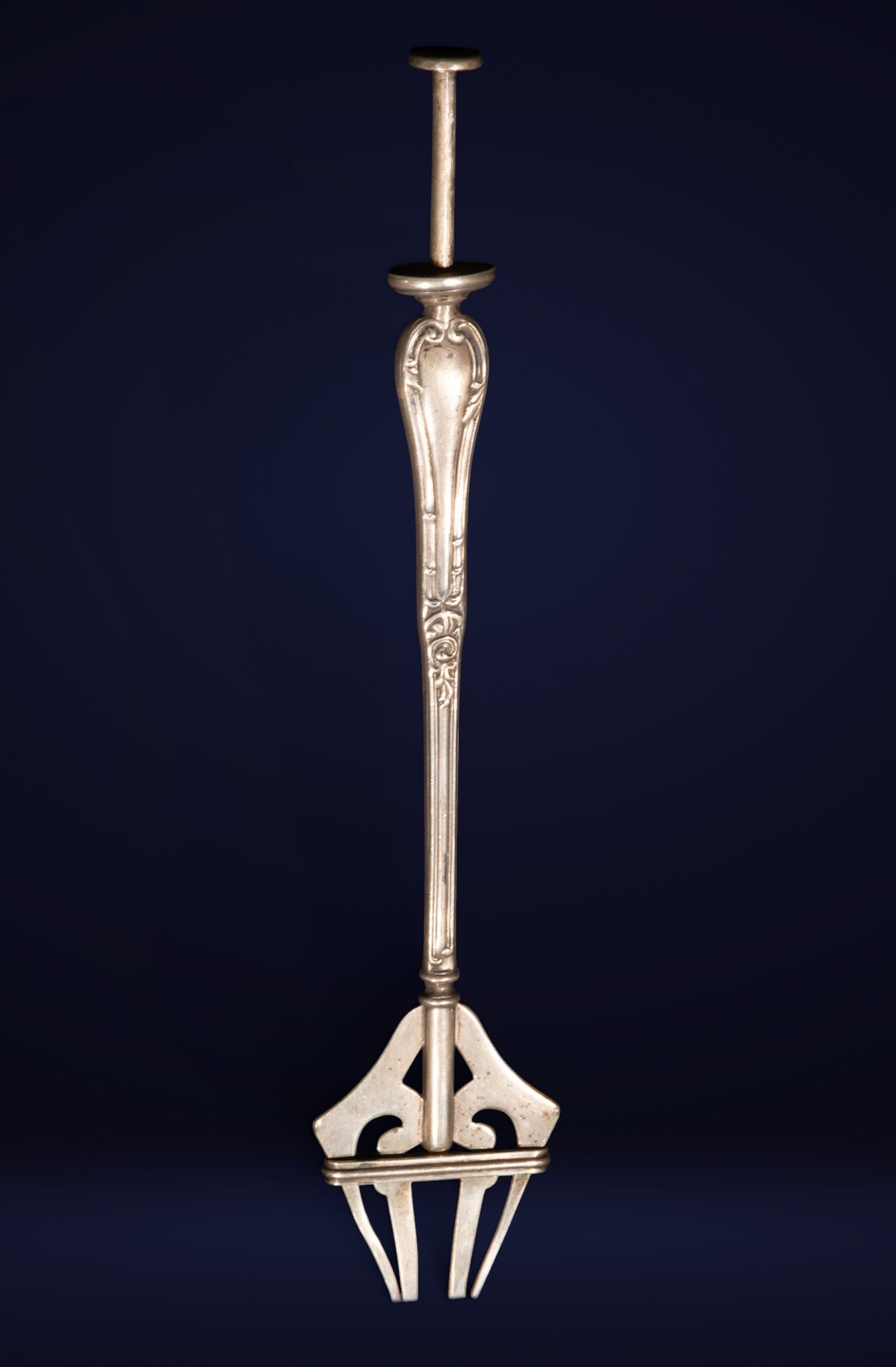 Silver hospitality piece with release mechanism, European School, 19th Century: Cast and molded silver. Dimensions: 14 x 5 x 1.5 cm. Tableware serving utensil with a push-and-release mechanism, conceived with a stylized structure of curved lines and understated, Art Nouveau-inspi