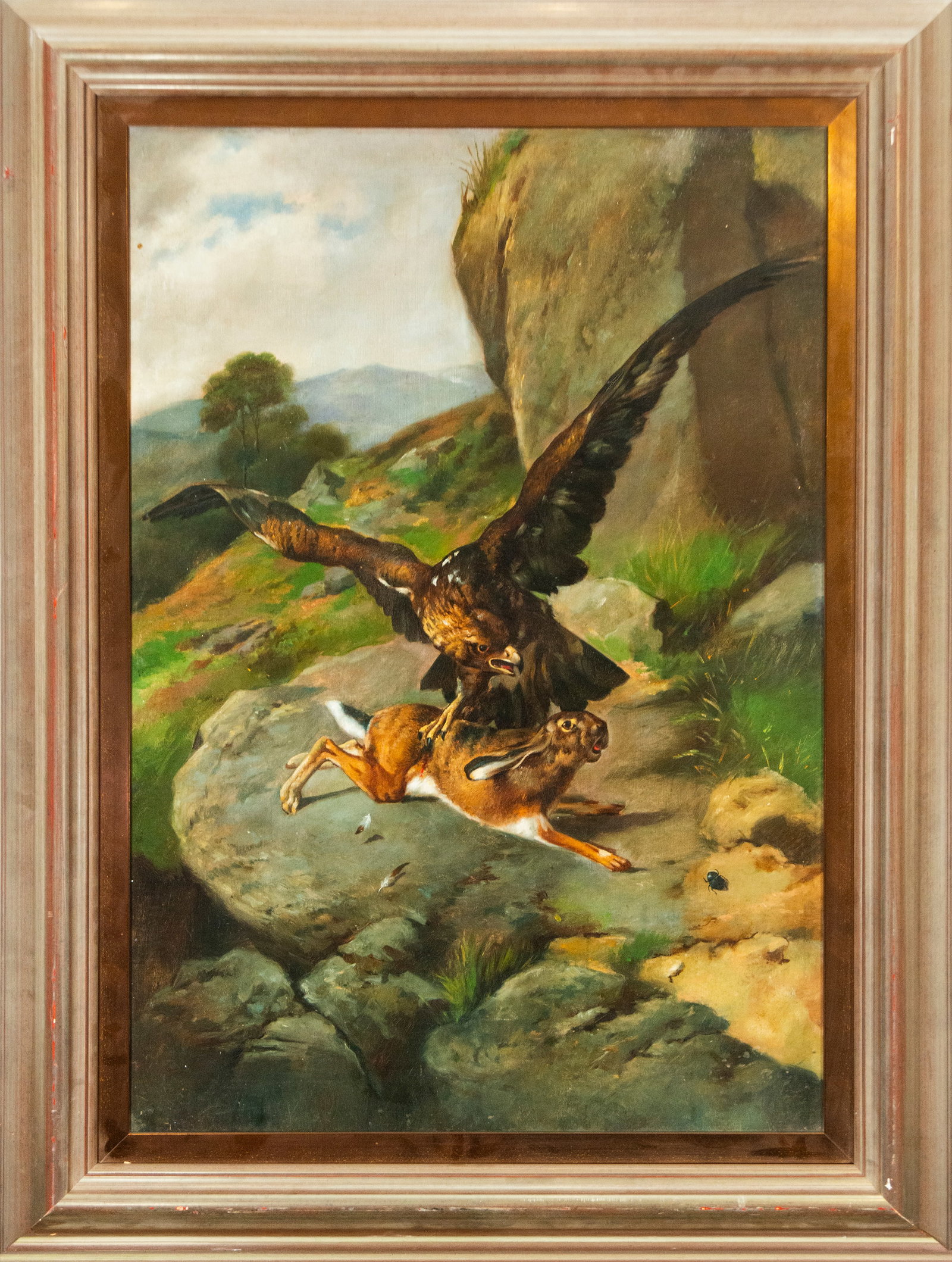 Eagle hunting, European School, 20th Century: Oil on canvas. Dimensions: 87 x 60 cm; 107 x 81 cm. An animal scene depicting an eagle with outstretched wings seizing a hare against a rocky mountain landscape. The composition emphasizes the drama o