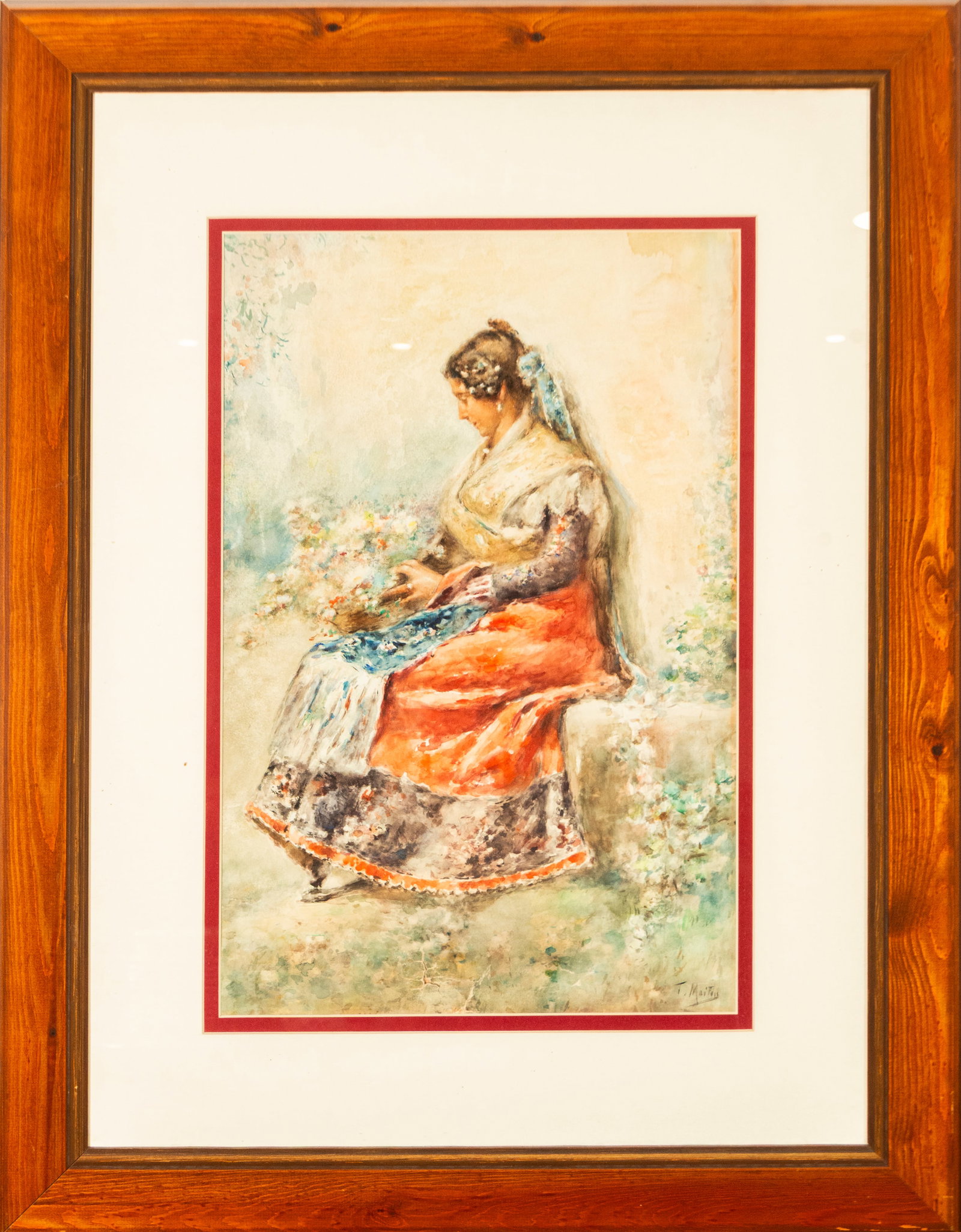 Seated Woman. Signed T. Maifus, Spanish School, 20th Century: Watercolor on paper. Dimensions: 49 x 30 cm; 76 x 57 cm. A seated female figure holds flowers in her hands, dressed in traditional regional attire consisting of a light-colored shawl, a reddish skirt,