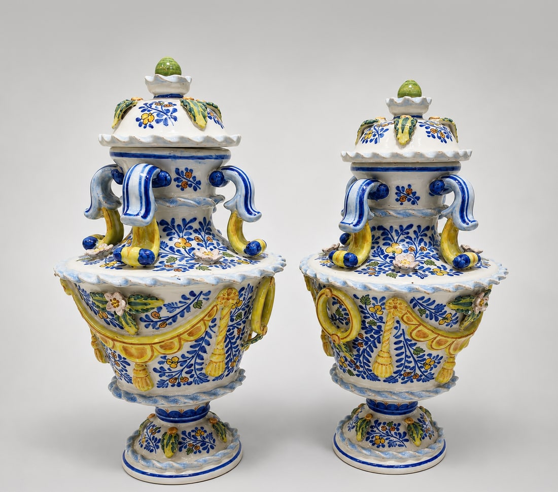 Pair of Italian Sorrentino majolica vases, Italian School, circa 1900: Polychrome glazed majolica. Measures 45 x 20 cm. Pair of ornamental vases with an elegant architectural profile, made of glazed ceramic and profusely decorated with floral motifs and vegetal elements 