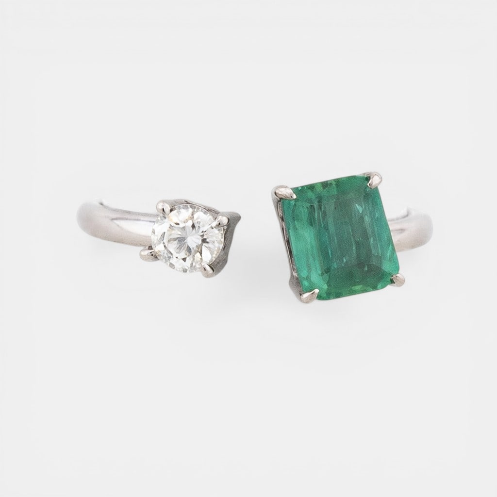 Ring with a natural emerald of approx. 1.10 ct and a diamond of approx. 0.25 ct.: Brilliant-cut diamond, approx. 0.25 ct; natural emerald, approx. 1.10 ct; 14K gold, approx. 3.30 g. An elegantly understated ring featuring a natural emerald enhanced by a central diamond, set in a cl