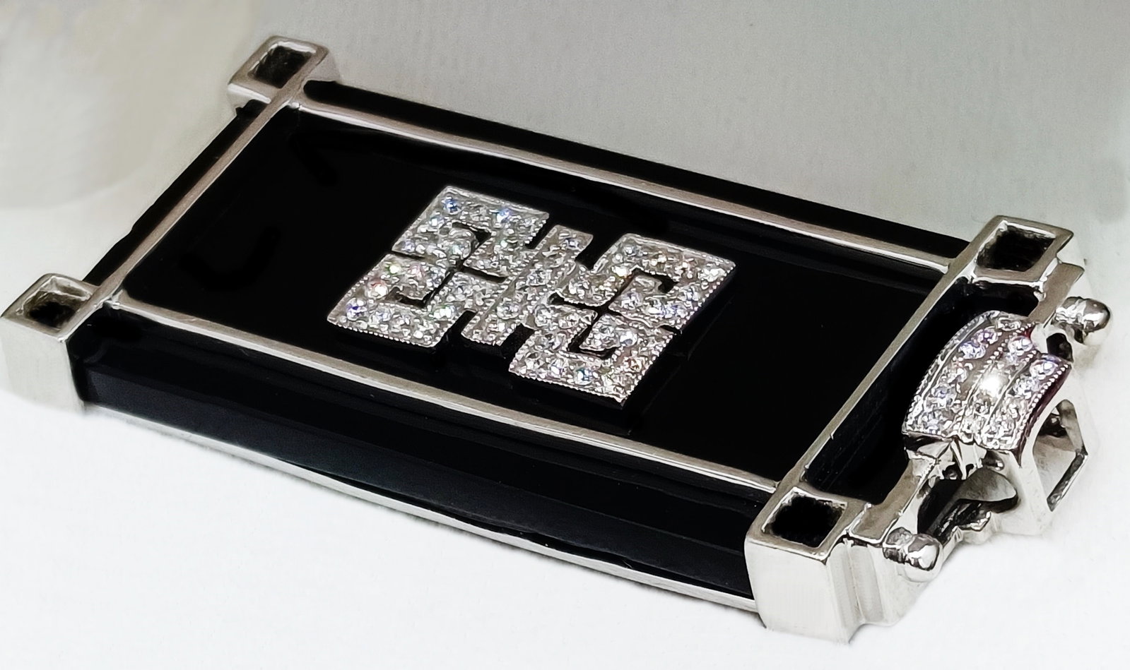 18k white gold pendant with diamonds and onyx, Cartier style, 20th century: Large, uniquely designed pendant crafted in 18k white gold (750) with 58 brilliant-cut diamonds totaling 0.42 carats, set in the center and at the top of the piece on a large onyx stone. It bears seve