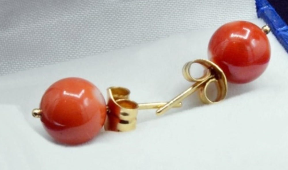 18K gold earrings with natural 9 mm coral and large clasps.: Earrings crafted in 18-karat bright yellow gold, featuring two 9mm diameter natural corals in a soft, untreated, angel-skin red. Comfortable settings and large, secure clasps. Weight: 2.9 grams.