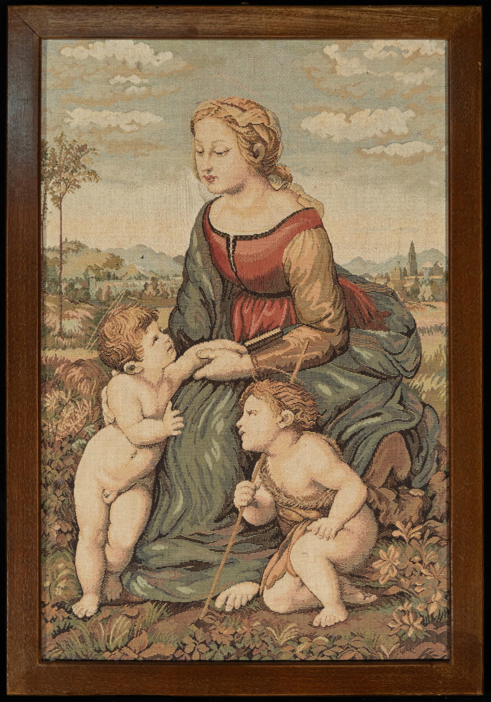 Seated Virgin with Child and Angels in Landscape, European School, 19th-20th Century: Tapestry. Measures 45 x 29 cm; 50 x 34 cm with frame. Scene with a seated female figure holding a book, accompanied by two naked children at her feet in an attitude of play and attention; the group is