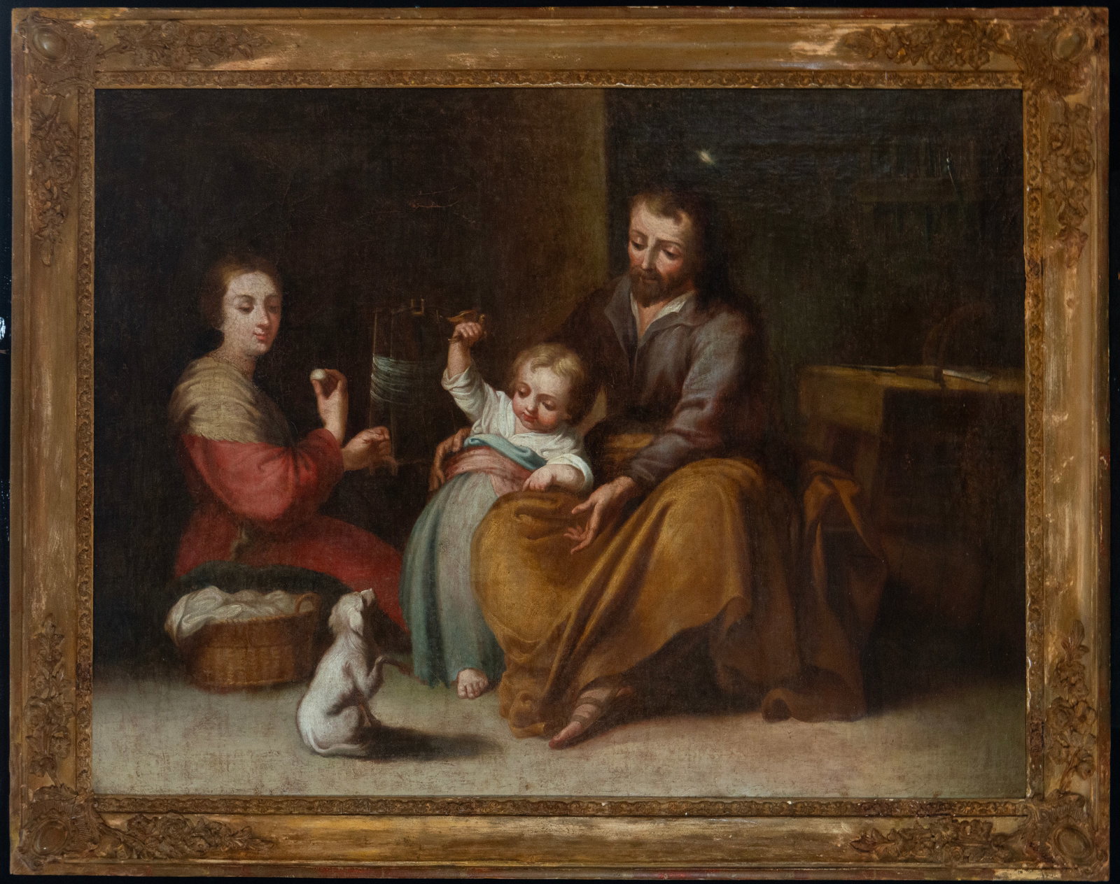 Holy Family in a domestic interior, following Murillo, Spanish school, 19th century: Oil on canvas. Dimensions 94 x 71 cm; framed 108 x 86 cm. An intimate scene of the Holy Family in a simple interior, with the Virgin Mary seated on the left next to a laundry basket, Saint Joseph on t