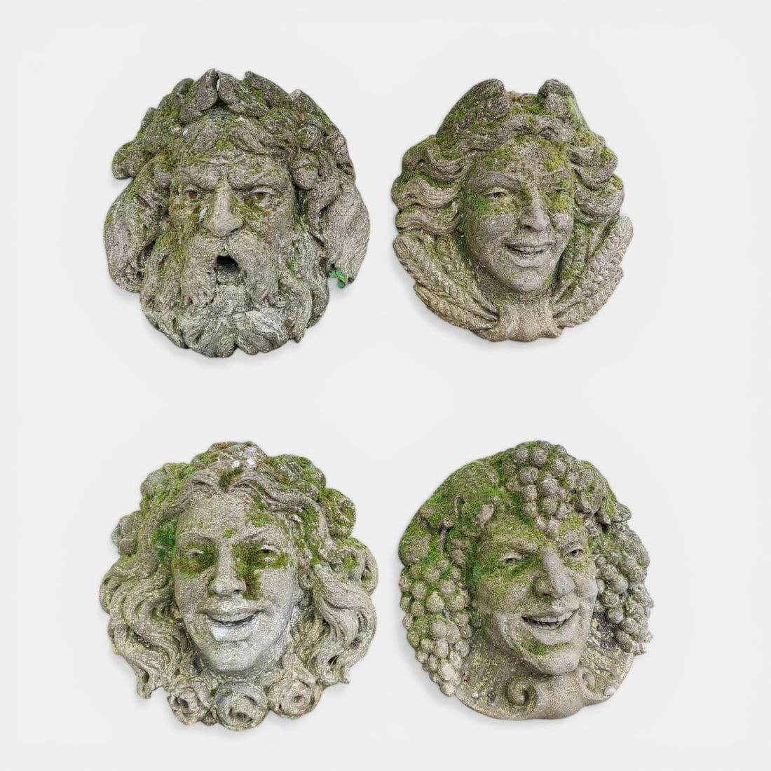 Collection of four mascarons with allegorical representations of the Seasons, Italy, 19th-20th: Carved Vicenza stone. Dimensions: 34 x 38 x 20 cm each. Set of four sculpted Vicenza stone mascarons representing the personifications of the Seasons, conceived as ornamental elements in the architect