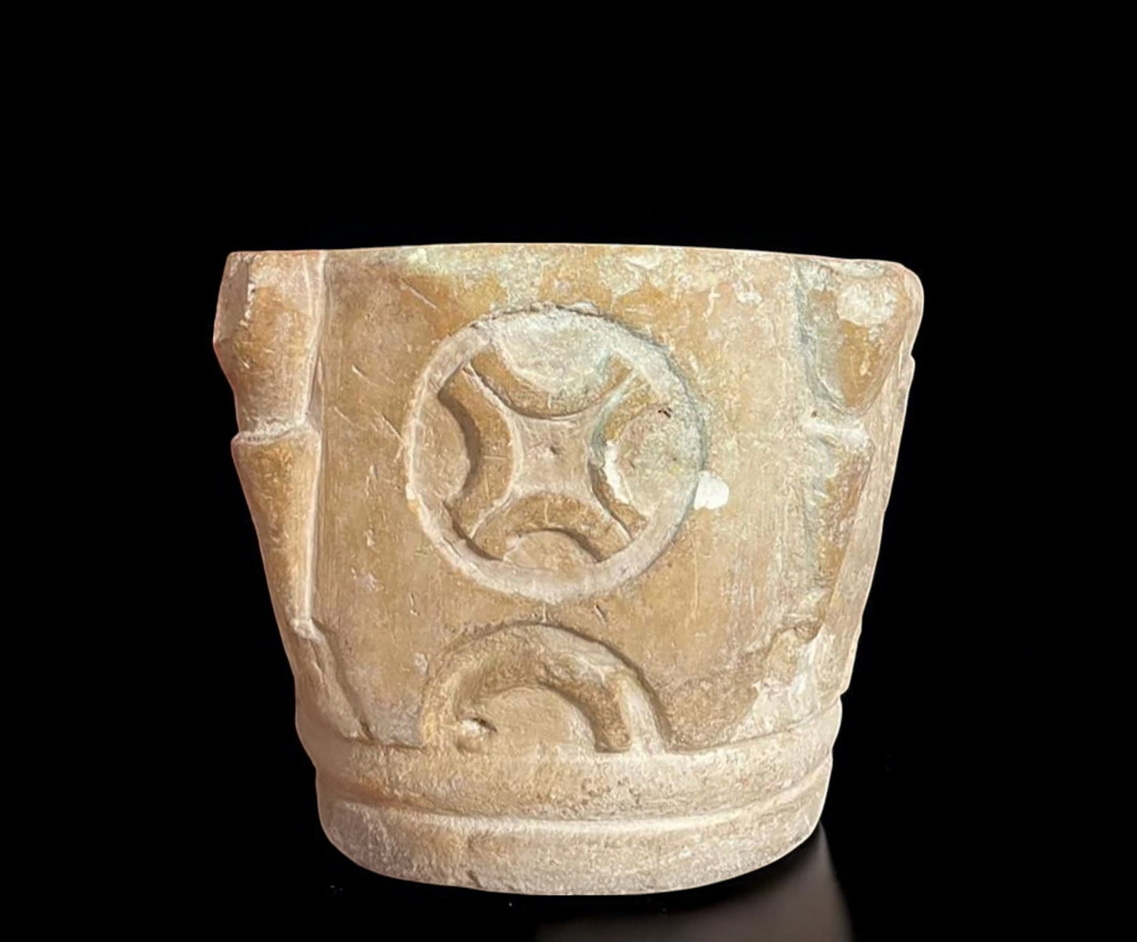 Medieval mortar with symbolic motifs, France, 12th century.: Carved stone mortar, made with a manual chiseling technique typical of medieval European art. The piece features relief decorations that include inscribed crosses and semicircular arches, common symbo