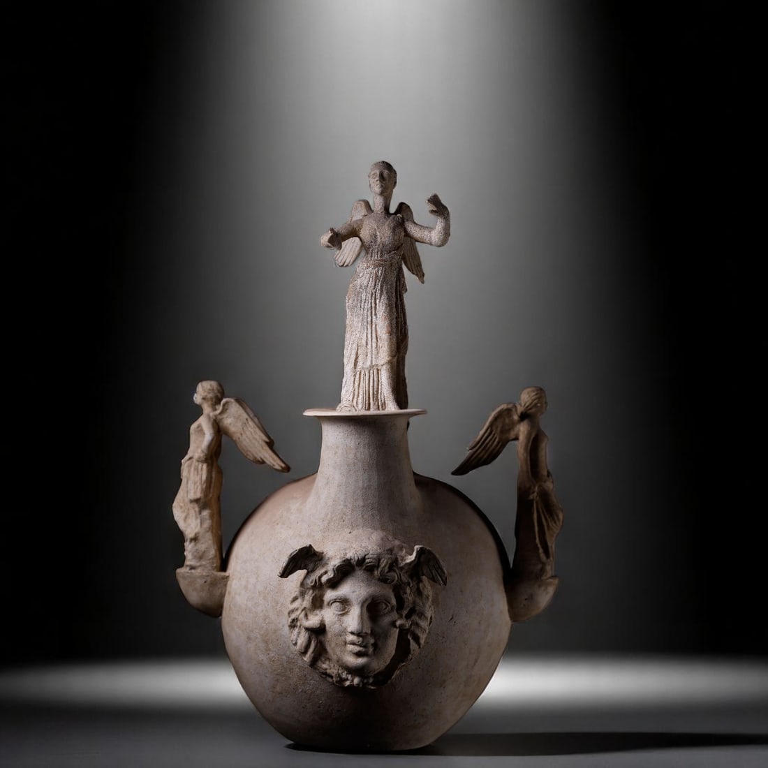 Monumental and Exceptional Greek Krater from the 3rd century BC with Medusa and Handles topped with: Monumental Canosan krater with figures of Medusa and deities, Canosa, Italy. Late 4th – 3rd century B.C. Approximate dimensions: 75 x 50 x 50 cm. An exceptional large-format piece from Canosa di Pug