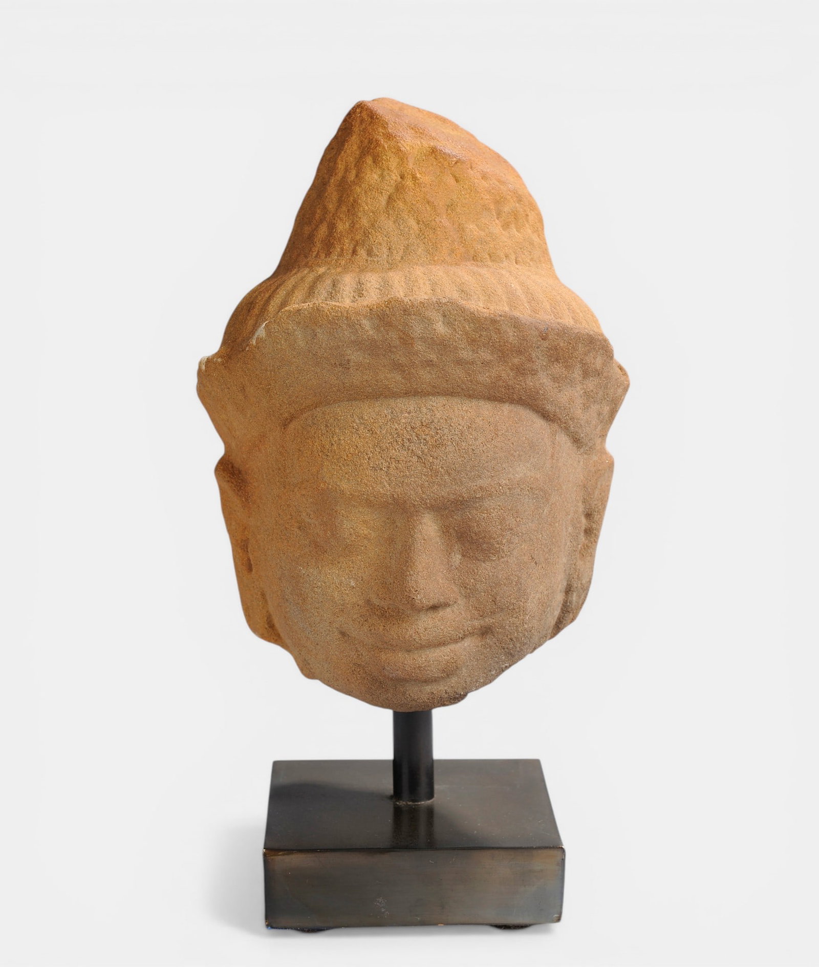 Buddha head with squinting eyes and curly hair arranged in braids (1 of 1)