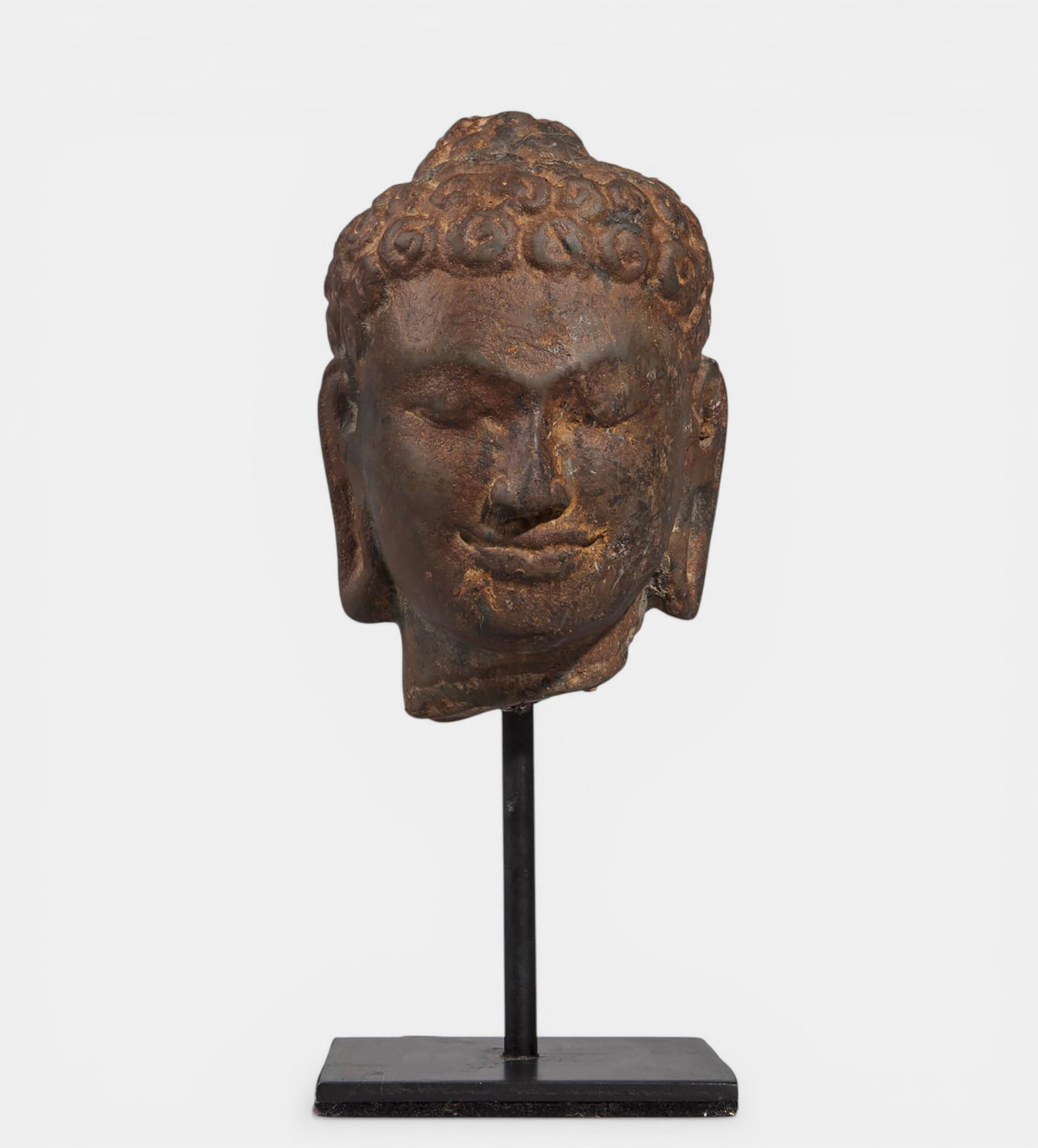 Buddha head with wide loops and ushnisha: Pink sandstone. Thailand. Kingdom of Dvaravati. 7th to 9th centuries. 12 cm. Lot in international warehouse (within the EU). Intra-EU shipment: no import duties apply within the EU. Export permit from