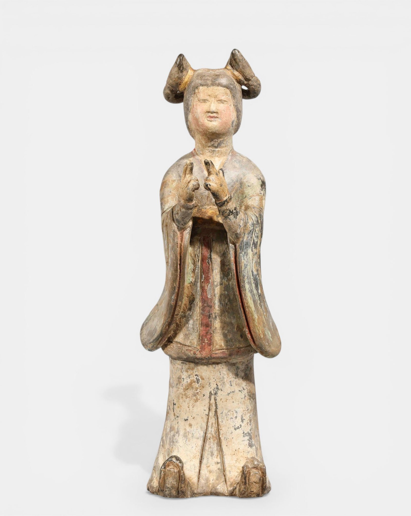 Court lady, Tang Dynasty. 618-907. Height 26 cm. China: Dressed in a long tunic with wide sleeves draped over a long skirt. Terracotta with traces of slip and polychromy. China. Tang Dynasty. 618 to 907. Height 26 cm. Lot in international warehouse (within