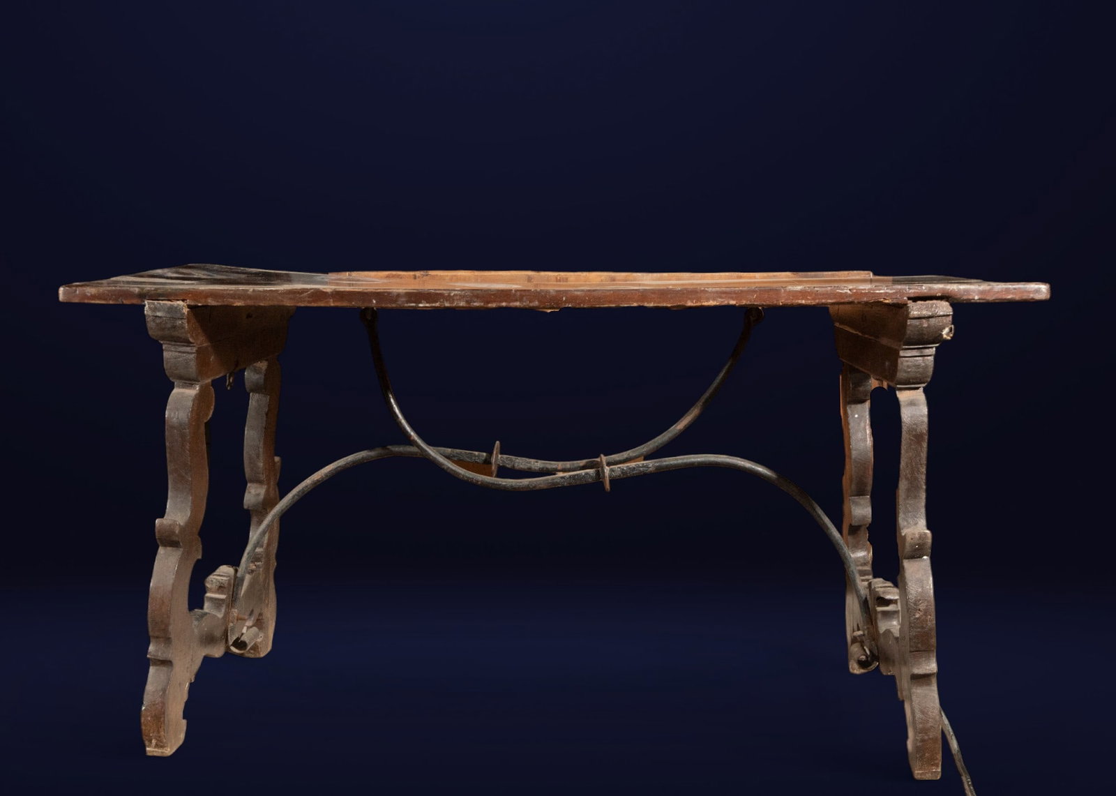 Spanish walnut lyre-leg table. Spanish School. 17th century.: Carved walnut wood. Measurements: 76 x 44 x 67 cm. 17th-century Spanish table with lyre legs, recognizable by their sinuous, curvilinear design, which lends dynamism to the piece. The rectangular tabl