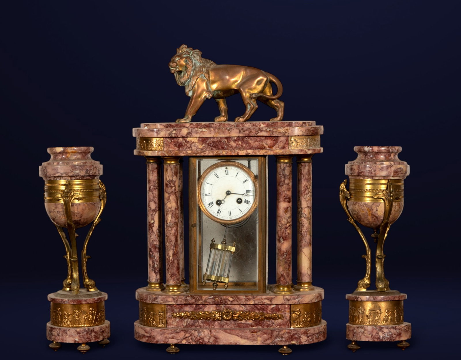 Bronze clock and candlestick mount with lion. French School. 19th century.: Marbled marble and gilt bronze. Dimensions: clock 58 x 33 x 13 cm; candlesticks 39 x 11 x 11 cm. 19th-century French mantelpiece composed of a central clock and two side candlesticks. The clock, crown