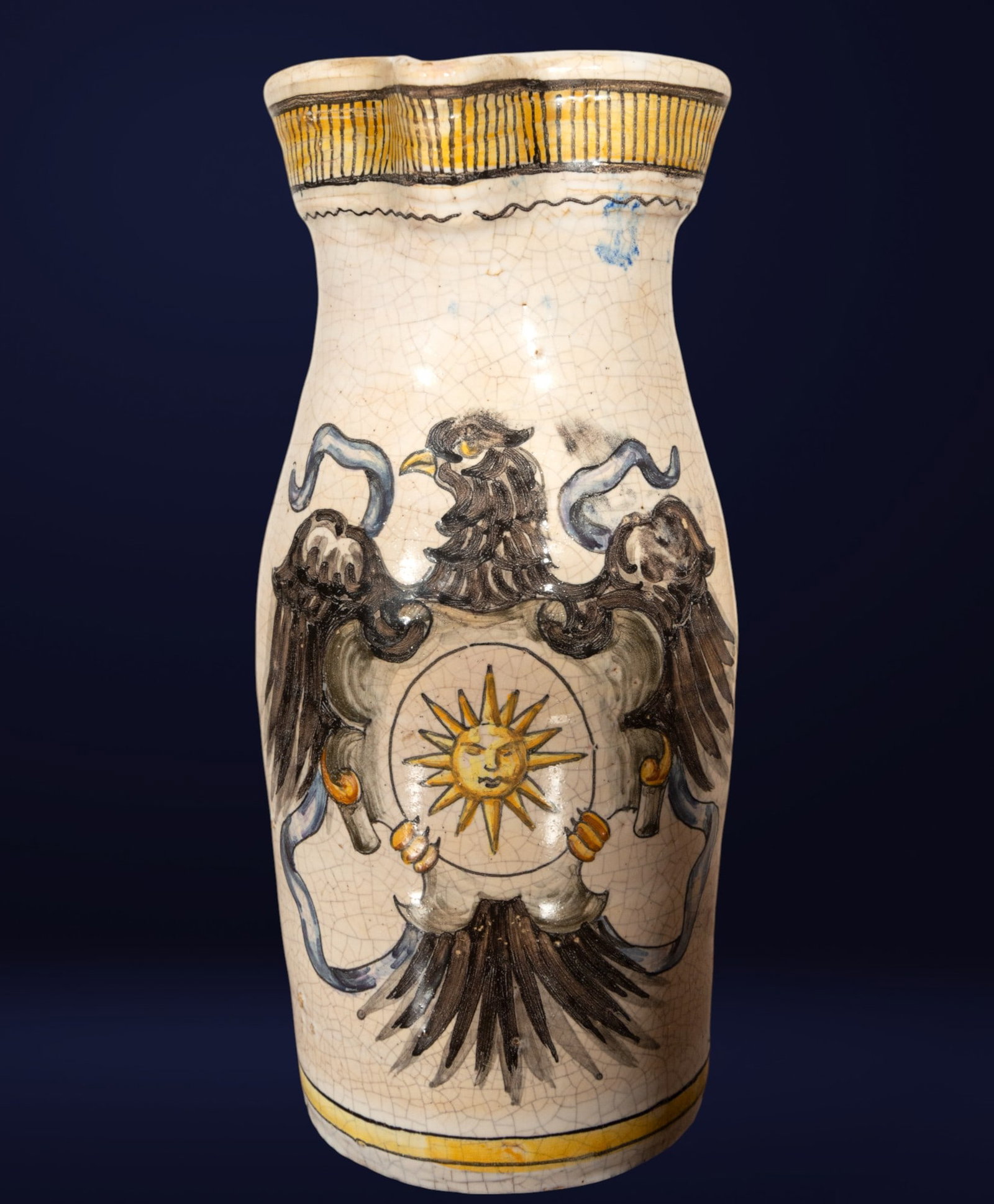 Wine jug from Talavera de la Reina with an eagle coat of arms. Spanish School. 19th century.: Glazed and polychrome ceramic. Measurements: 30 x 13 x 12 cm. Wine jug made in Talavera de la Reina during the 19th century, decorated with glazed enamel on a white background. Its front features a sh
