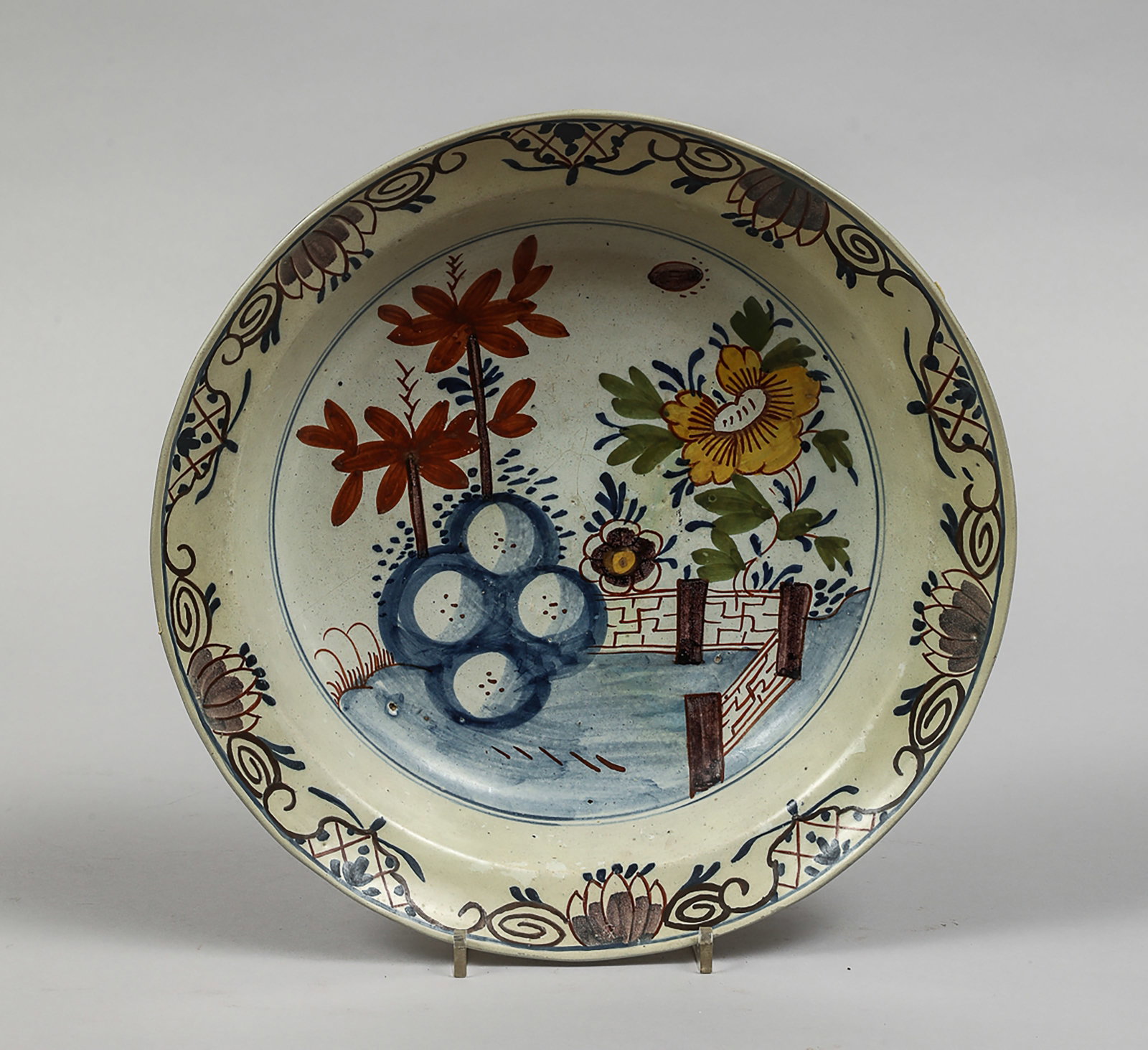 Polychrome earthenware plate with stylized floral composition (1 of 2)