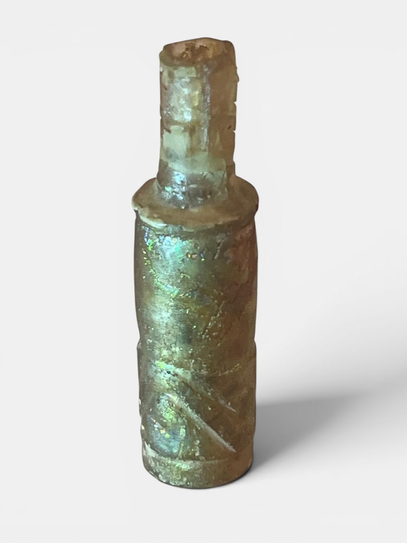 Archaeological fusiform cylindrical cosmetic bottle of iridescent glass (1 of 2)