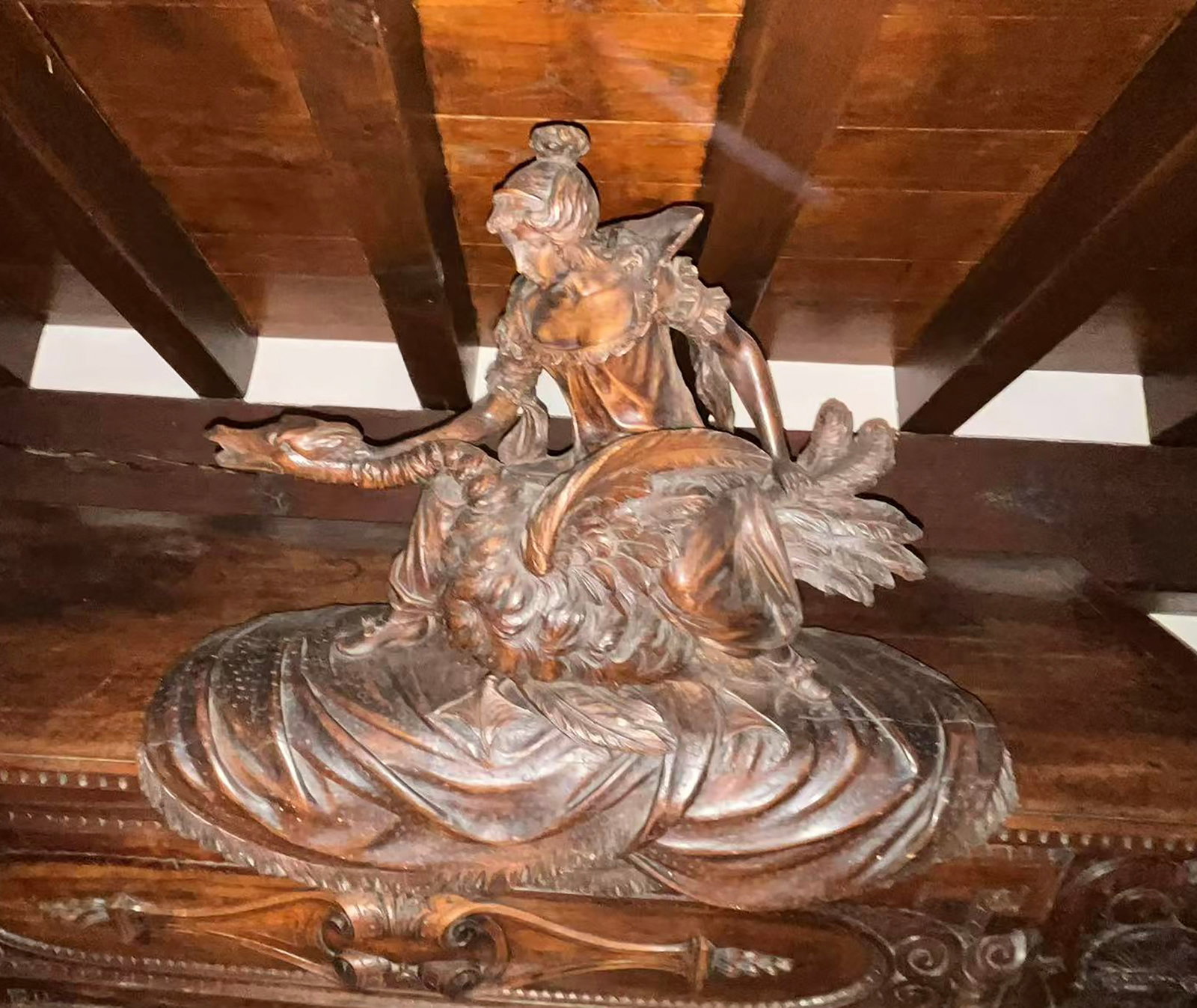 Allegorical female figure carved in the round: It depicts a draped young woman, seated or in motion, on a naturalistic base with stylized scrolls, clouds, or foliage. The figure adopts a graceful and dynamic pose, with her torso inclined and her a