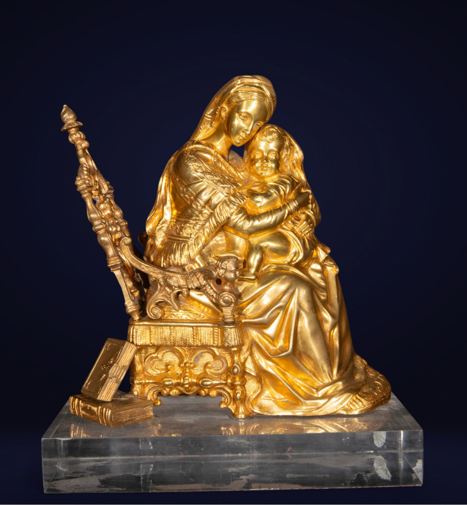 Virgin of the Chair in gilt bronze with mercury, French Restoration Period, 19th century, France: Gilded bronze. Measures 24 x 20 x 10 cm. Devotional group depicting the Virgin seated and embracing the Child, both on a richly ornamented chair. An open book lies at their feet, while the folds of th