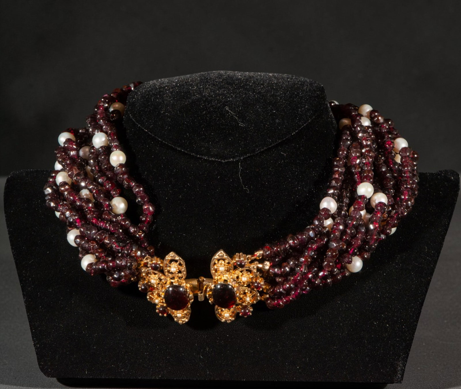 Gold-plated silver necklace with garnets and pearls: Gold-plated silver necklace with garnets and pearls. The piece features several rows of dark red garnet beads interspersed with light pearls, and a decorative gold-plated metal clasp with a central ap