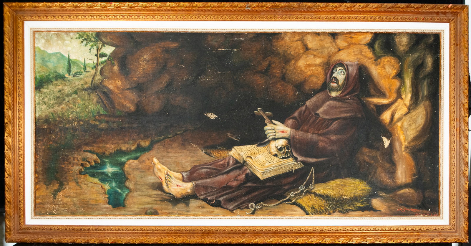 Saint Francis in meditation. Spanish school. 19th-20th centuries: Oil on canvas. Dimensions 73 x 163 cm. Religious composition depicting Saint Francis of Assisi in contemplative pose inside a grotto, accompanied by penitential symbols such as a skull, a crucifix, an