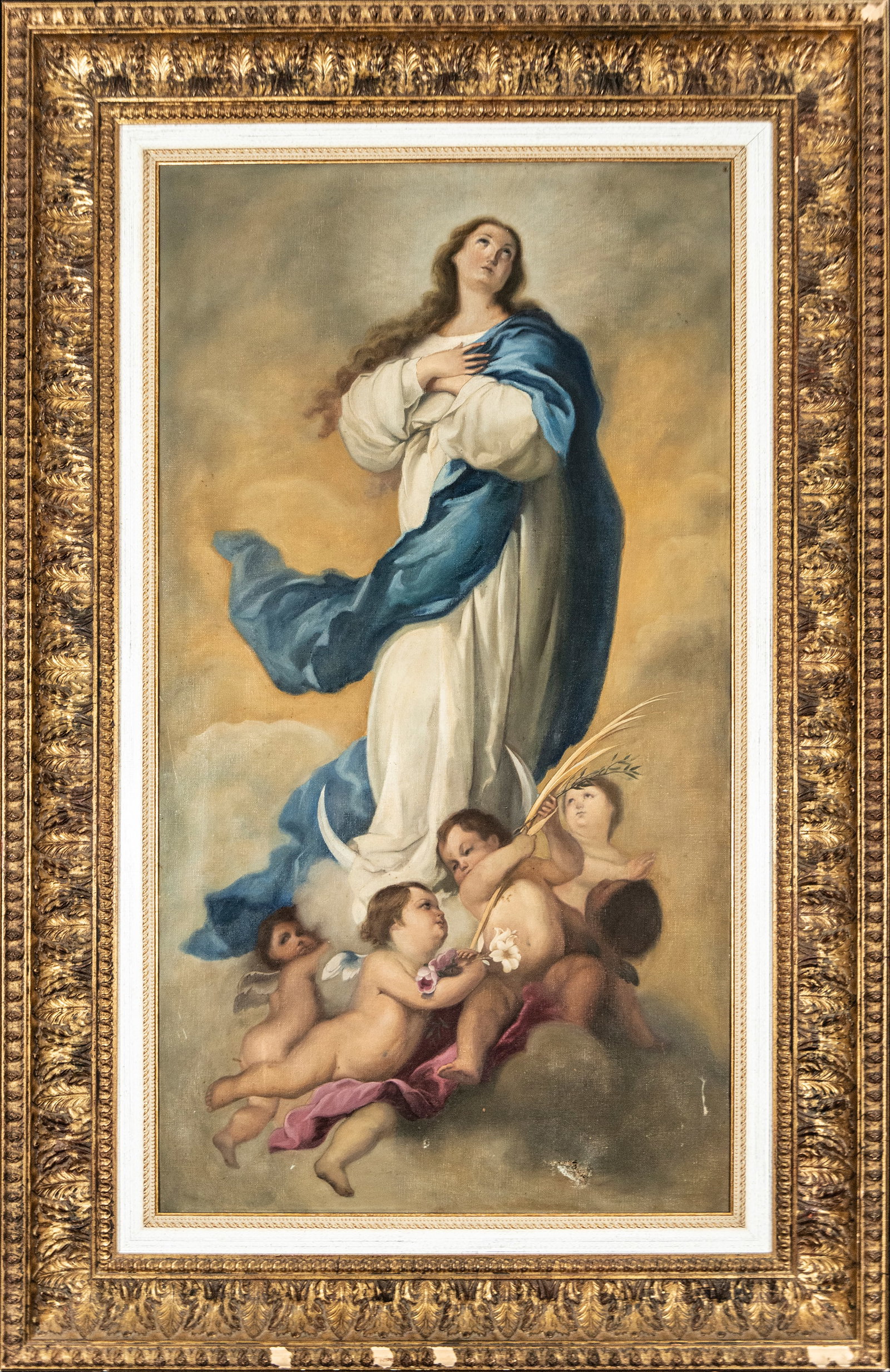 The Immaculate Conception. Spanish School. 19th-20th Centuries: Oil on canvas. Measures 100 x 54 cm. Image of the Immaculate Conception elevated on clouds and accompanied by cherubs. The figure appears enveloped in a white tunic and blue mantle, following traditio