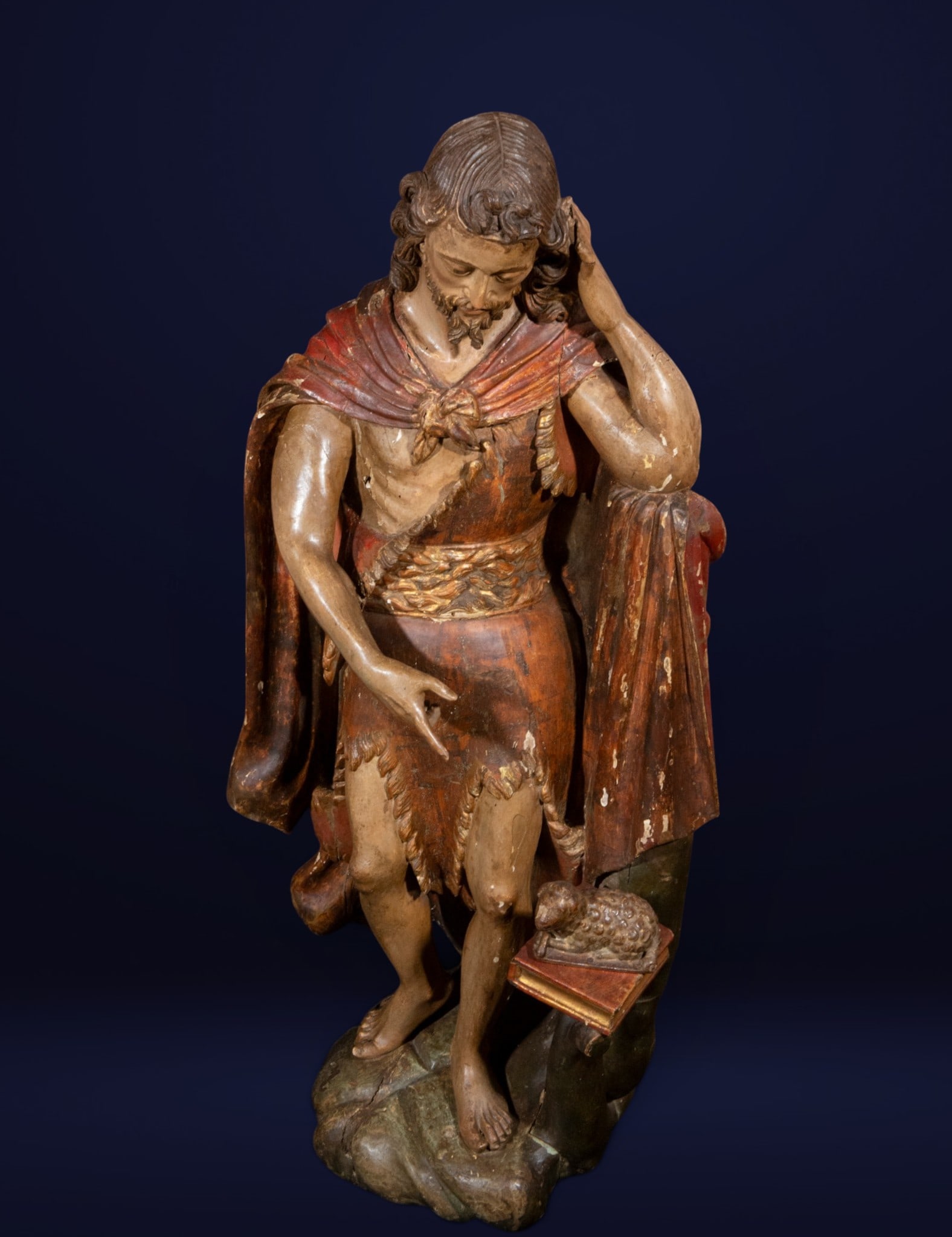 Saint John the Baptist, Spanish School, 18th Century: Carved and polychromed wood. Measures 97 x 46 x 41 cm. Devotional sculpture of Saint John the Baptist, identifiable by the camel skin that partially covers his body and by the presence of the lamb, sy