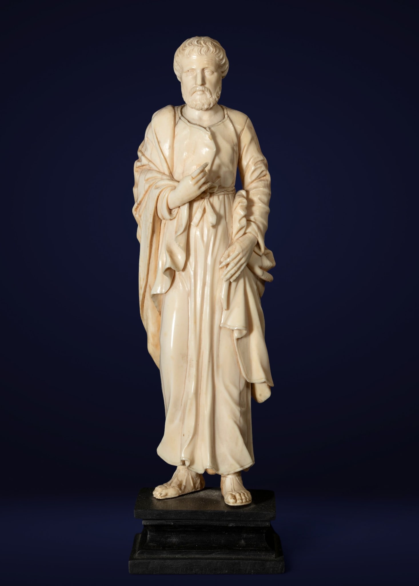 Carved bone sculpture of an apostle, Italy, 17th century: Sculpture in carved bone. Height: 18 cm. This sculpture represents a standing apostle, dressed in a wide, close-fitting tunic and a mantle draped over his shoulders, following the traditional models o