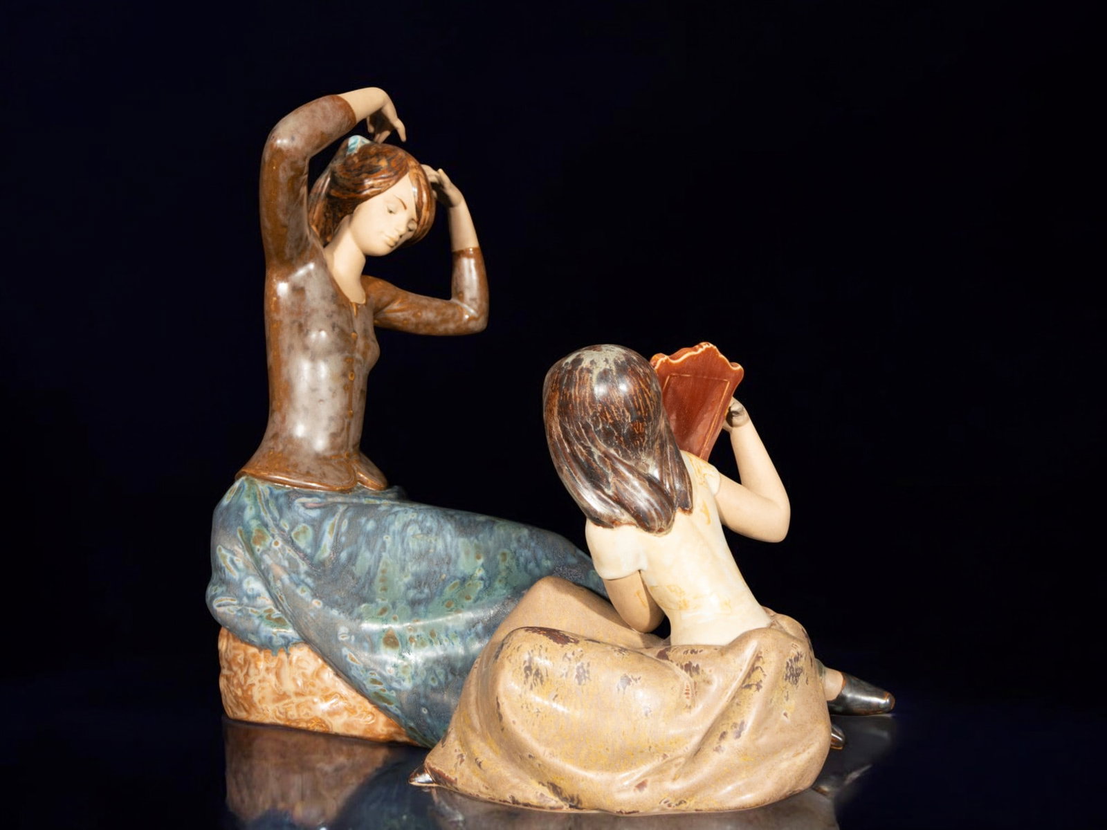 Porcelain woman combing her hair with girl in the mirror: Porcelain, 37 cm x 36 cm x 19 cm.