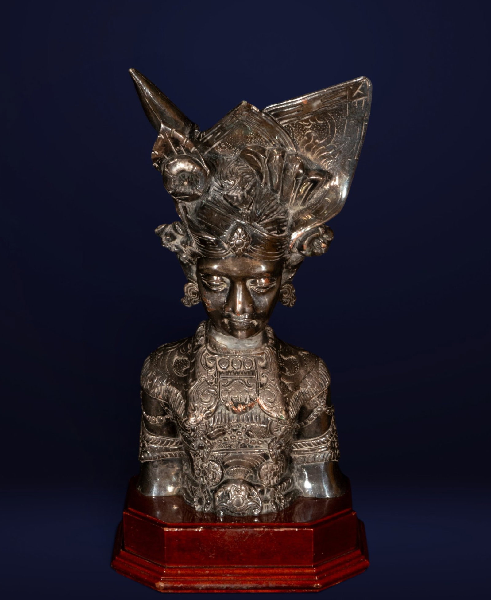 Orientalist bust, 20th century: Repoussé and chased silver. Measures 36 x 18 x 15 cm. Female bust inspired by Indonesian courtly tradition, adorned with an elaborate ceremonial ornament of significant vertical development and rich 
