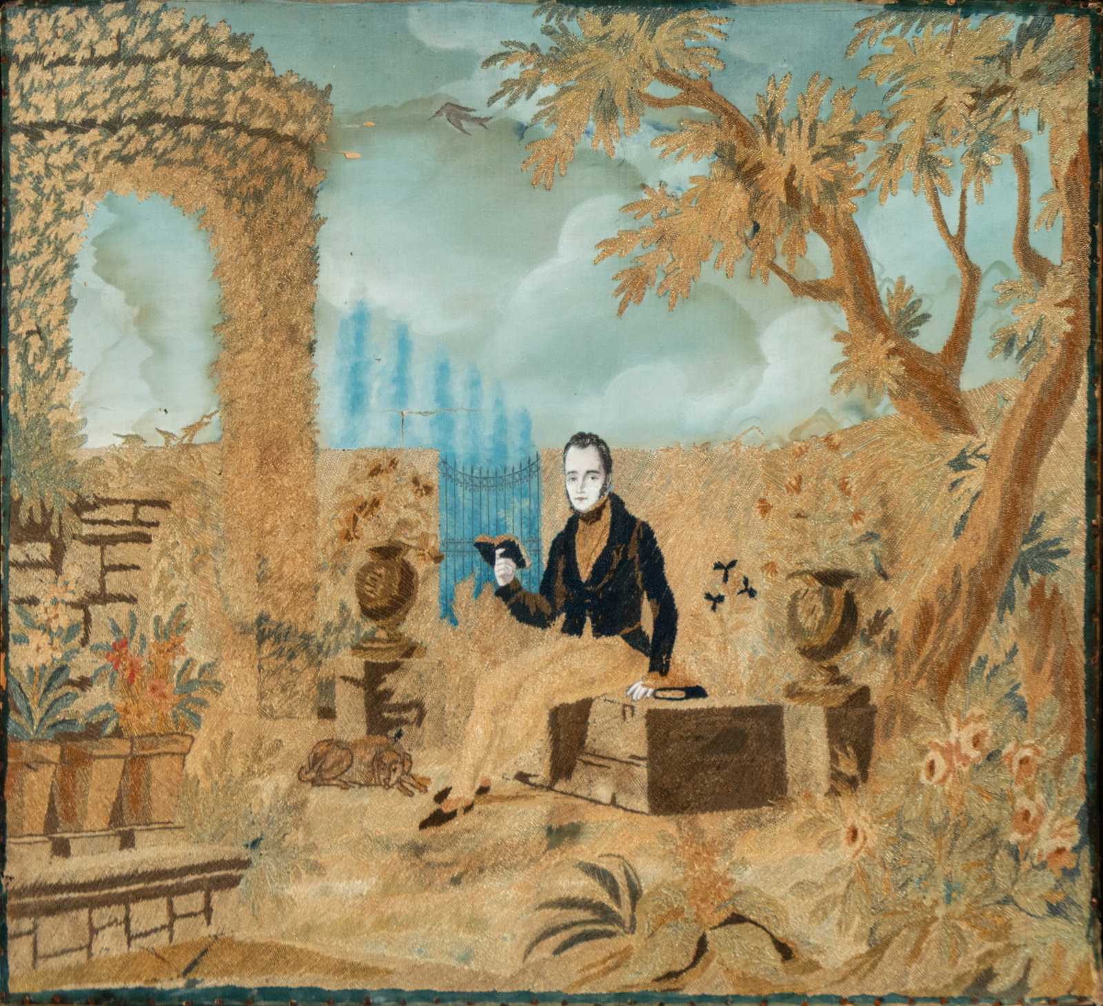 Rare 19th-century French embroidered portrait: Polychrome embroidery on fabric. Measures 42 x 49 cm. A gallant scene set in an idealized garden where a gentleman is seated amidst plants, ornamental architecture, and floral motifs. The composition 