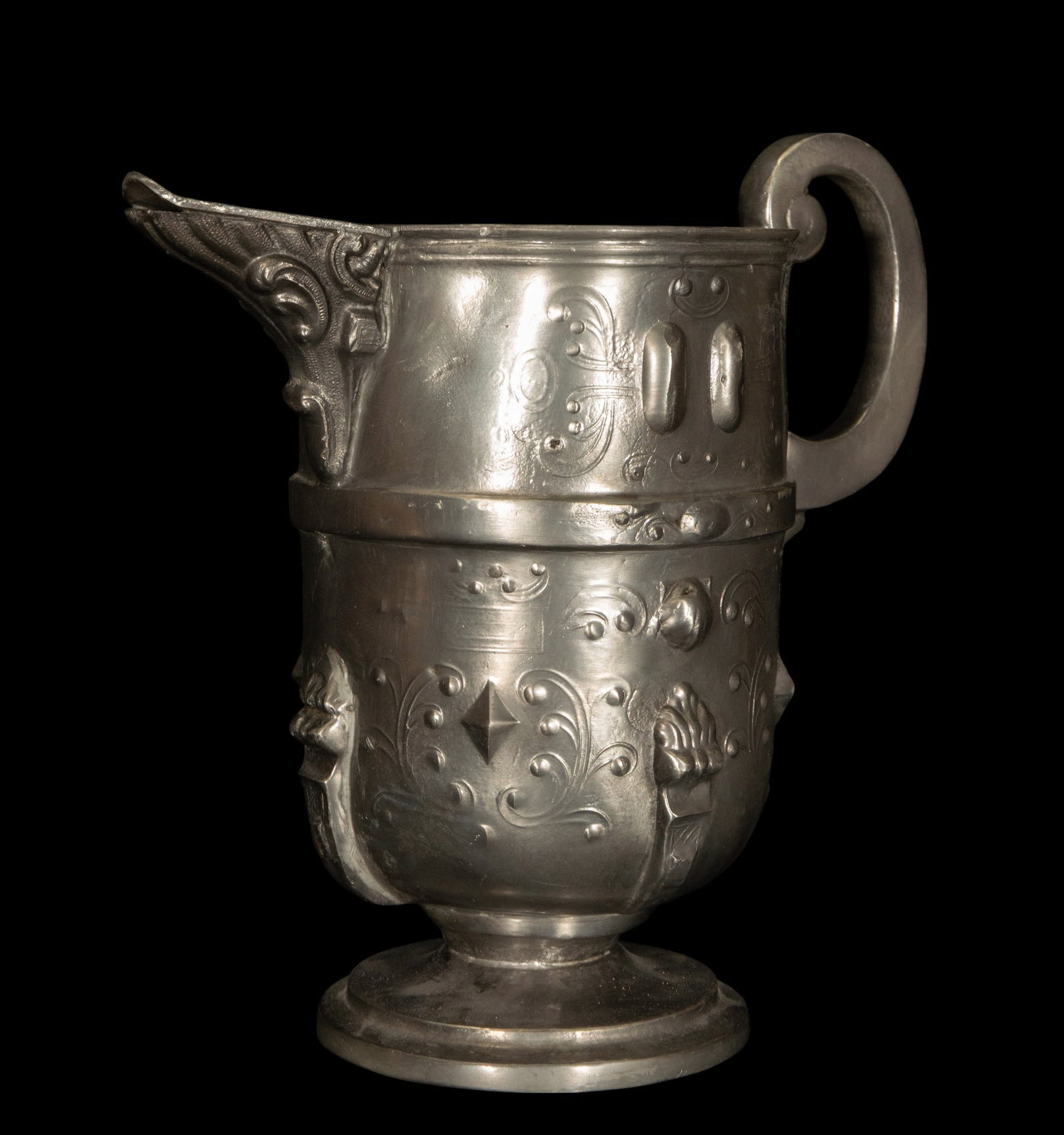 Tin spouted jug, Germanic School. 17th century: Molded and engraved pewter. Spouted jug with a slightly curved cylindrical body, a truncated cone-shaped base, and a high neck, topped with a spout-shaped pouring spout with embossed plant decoration.
