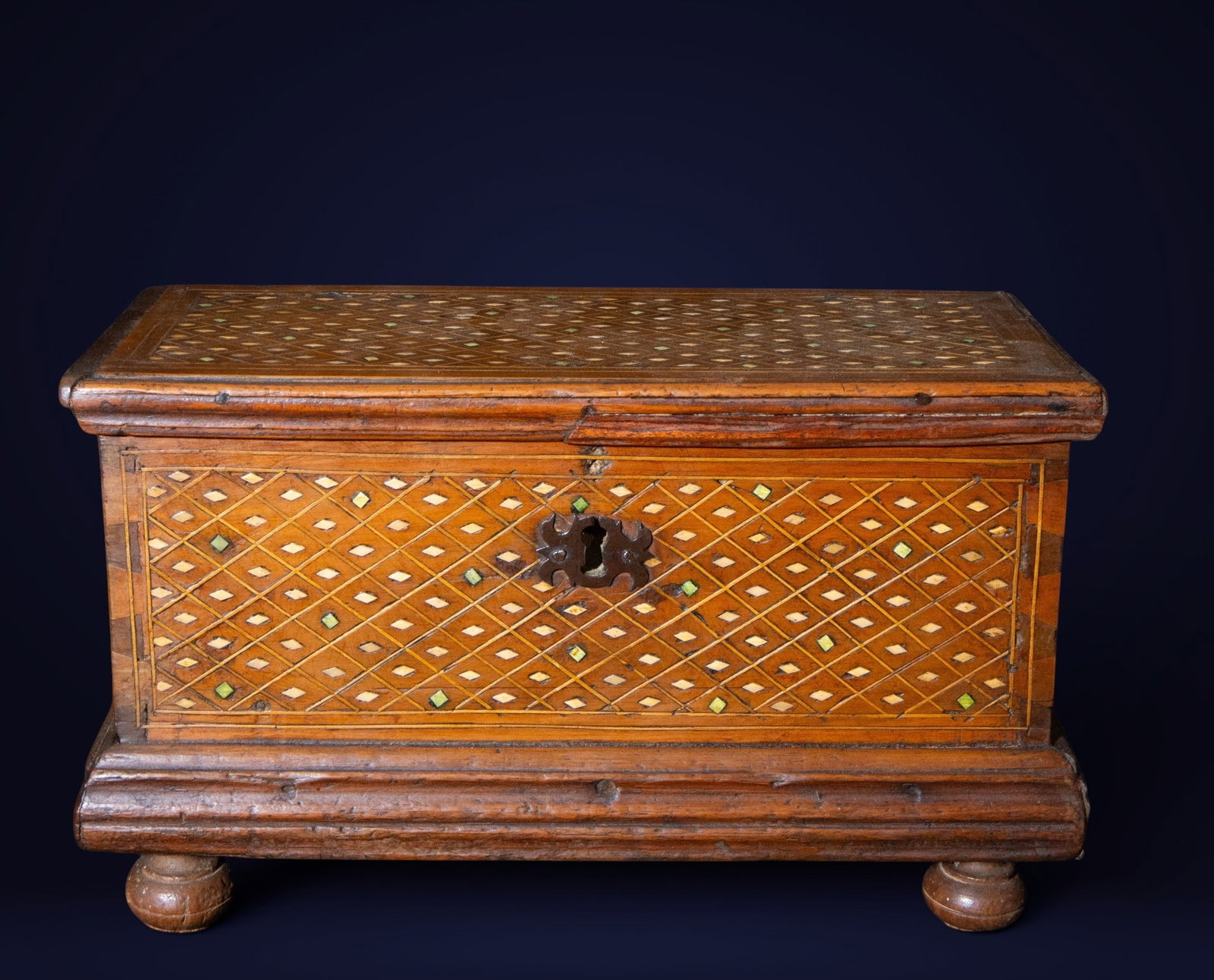 Aragonese bank, Aragonese School, 17th century: Walnut wood with marquetry and inlays. Measures 19 x 32 x 15 cm. Rectangular box raised on turned feet and decorated with meticulous geometric marquetry on the lid and front. Rhomboid motifs formed by