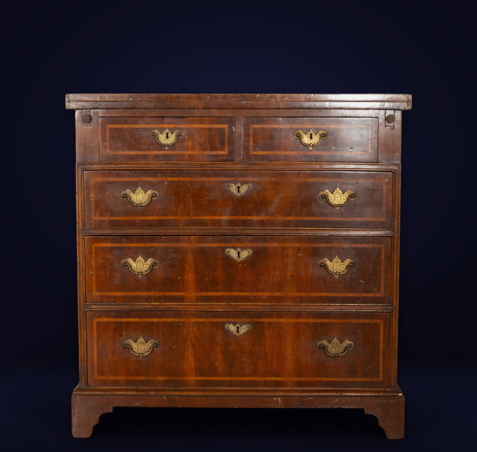 Chest of drawers in fine wood with marquetry and bronze keyholes, 19th century: Stained wood, marquetry, and bronze applications. Dimensions: 81 x 35 x 84 cm.