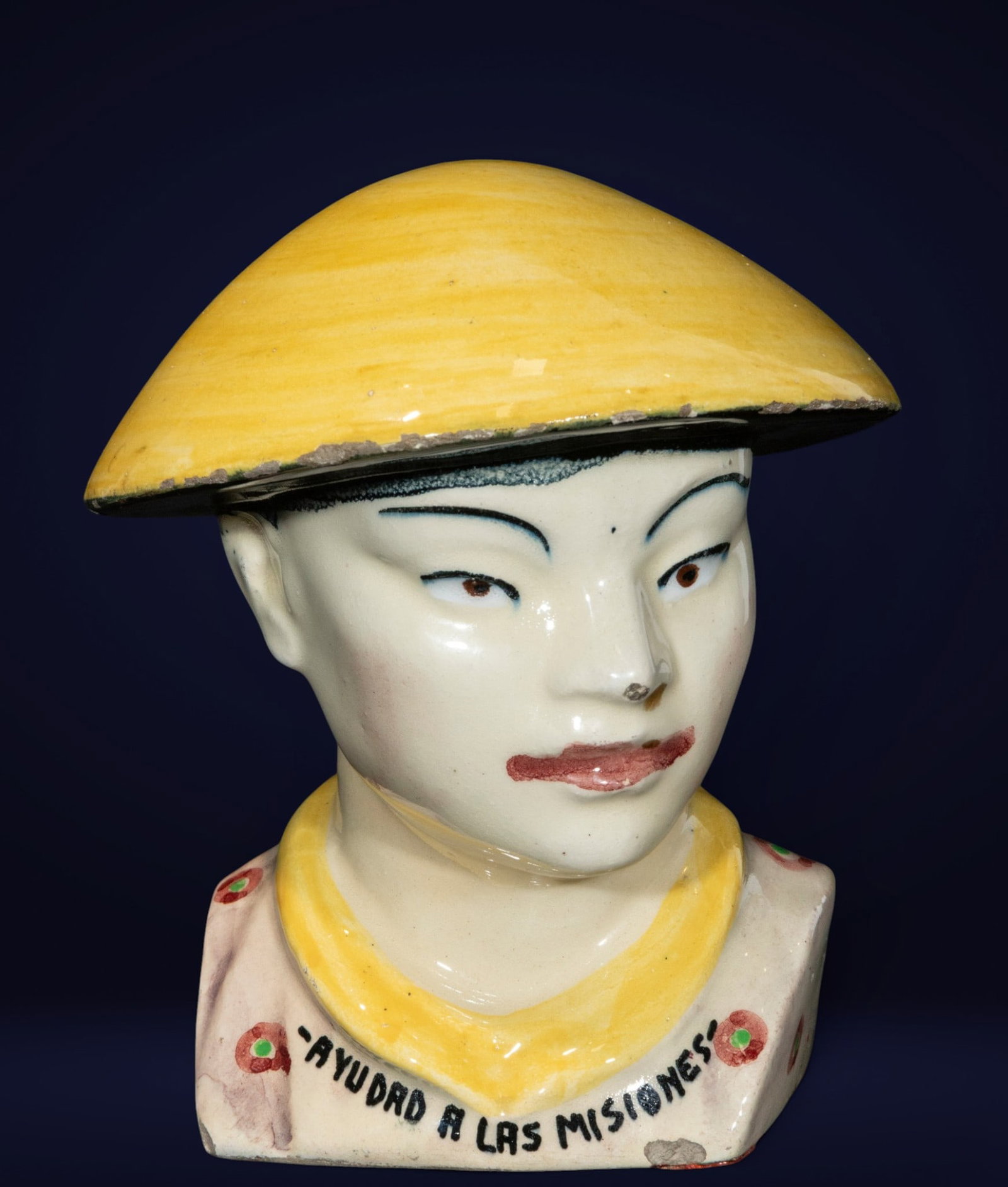 Rare "Aid to Missions" Money Box, Spanish School, 20th Century: Polychrome porcelain. Measures 18 x 16 x 16 cm. Male figure with oriental features, wearing a conical hat and traditional clothing. The stylized modeling and glazed decoration reflect the popular deco