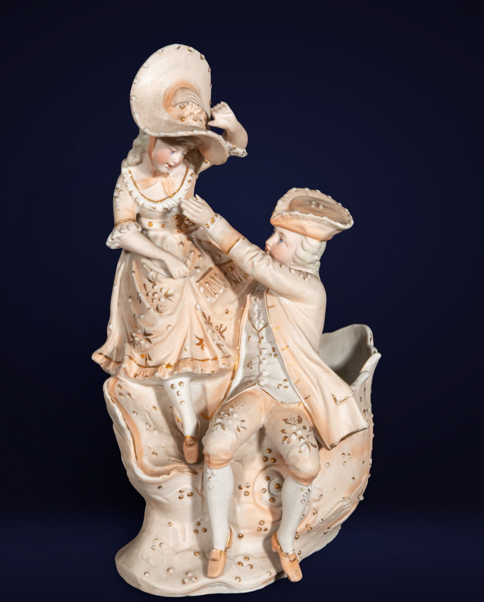 Porcelain figurine of a gallant couple. French or English school. 19th century.: Polychrome porcelain sculpture depicting a couple dressed in Rococo fashion, with fine gilt details. Dimensions: 22 x 16 x 12 cm. A Romantic-style piece, typical of 19th-century European craftsmanship