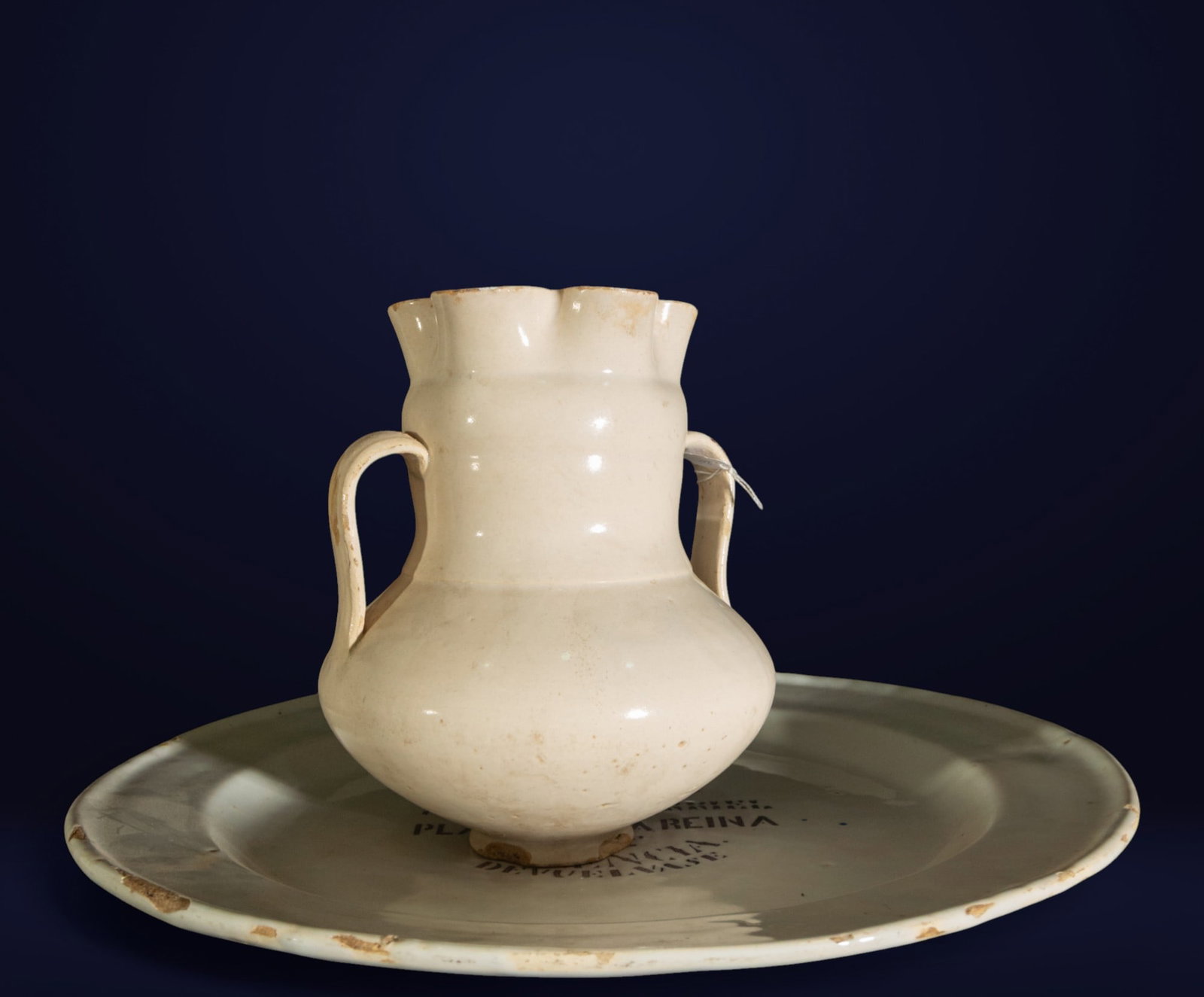 Jug and Plate, Valencian School, 19th Century: Cream-glazed ceramic. Measurement: Jug: 23 x 16 x 16 cm; Plate: 4 x 42 x 42 cm. Domestic set consisting of a globular-bodied jug with double handle and a large circular plate. Both pieces feature a li