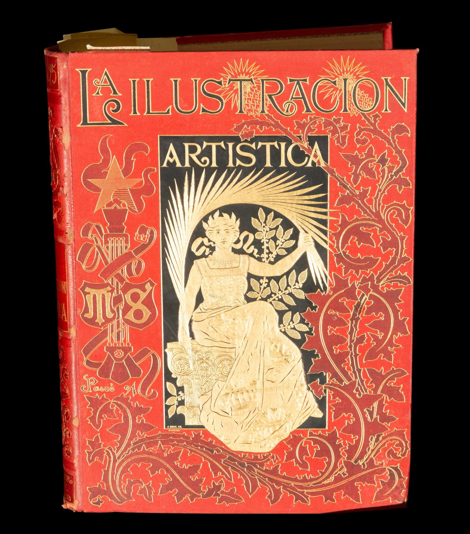 The illustration of 1825. Nineteenth-century publishing school. 19th century: Hardcover book with gold foil stamping on a red background. The cover features a distinctly allegorical composition, featuring a seated female figure, elegantly dressed in a tunic, surrounded by ornam