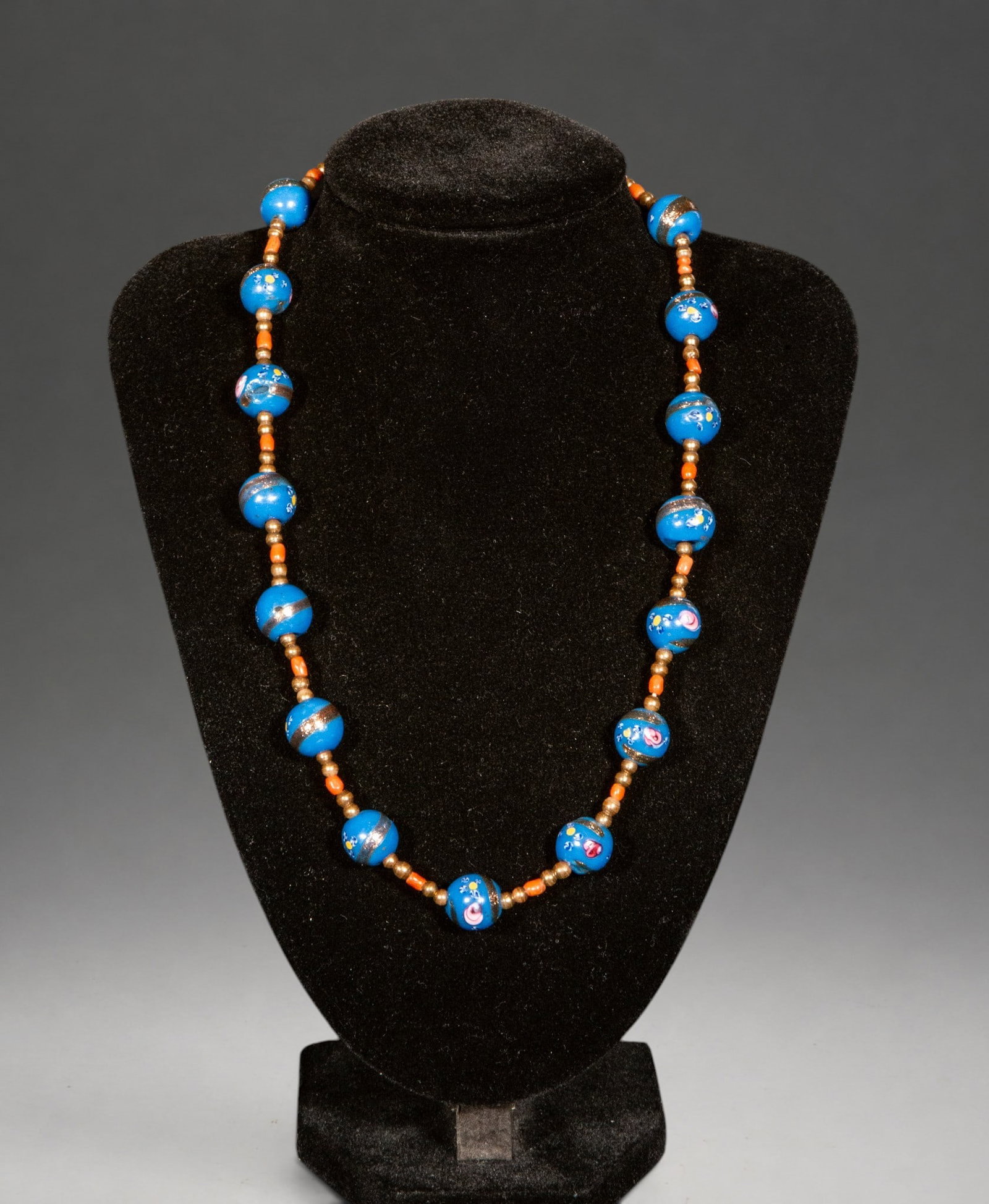 Murano glass and coral necklace with silver clasp: Necklace composed of blue Murano glass beads with applied decoration, interspersed with small coral beads and metal elements. The silver clasp completes a piece of striking color contrast and handcraf