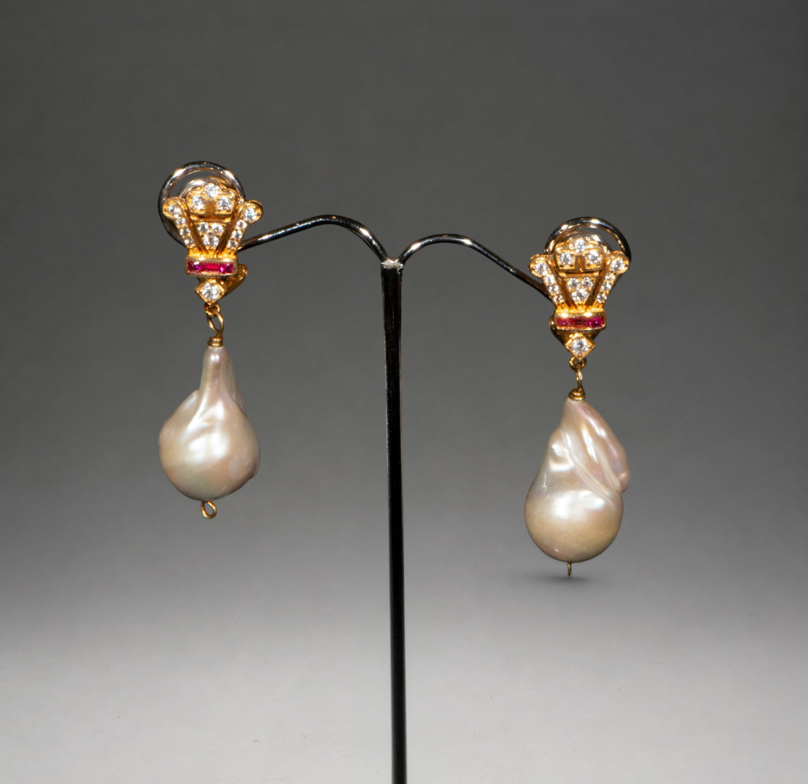 Gold-plated silver earrings with synthetic rubies and baroque pearl: Gold-plated silver earrings with synthetic rubies, cubic zirconia, and large dangling baroque pearls. Elegant, classically inspired design with a striking contrast of textures.
