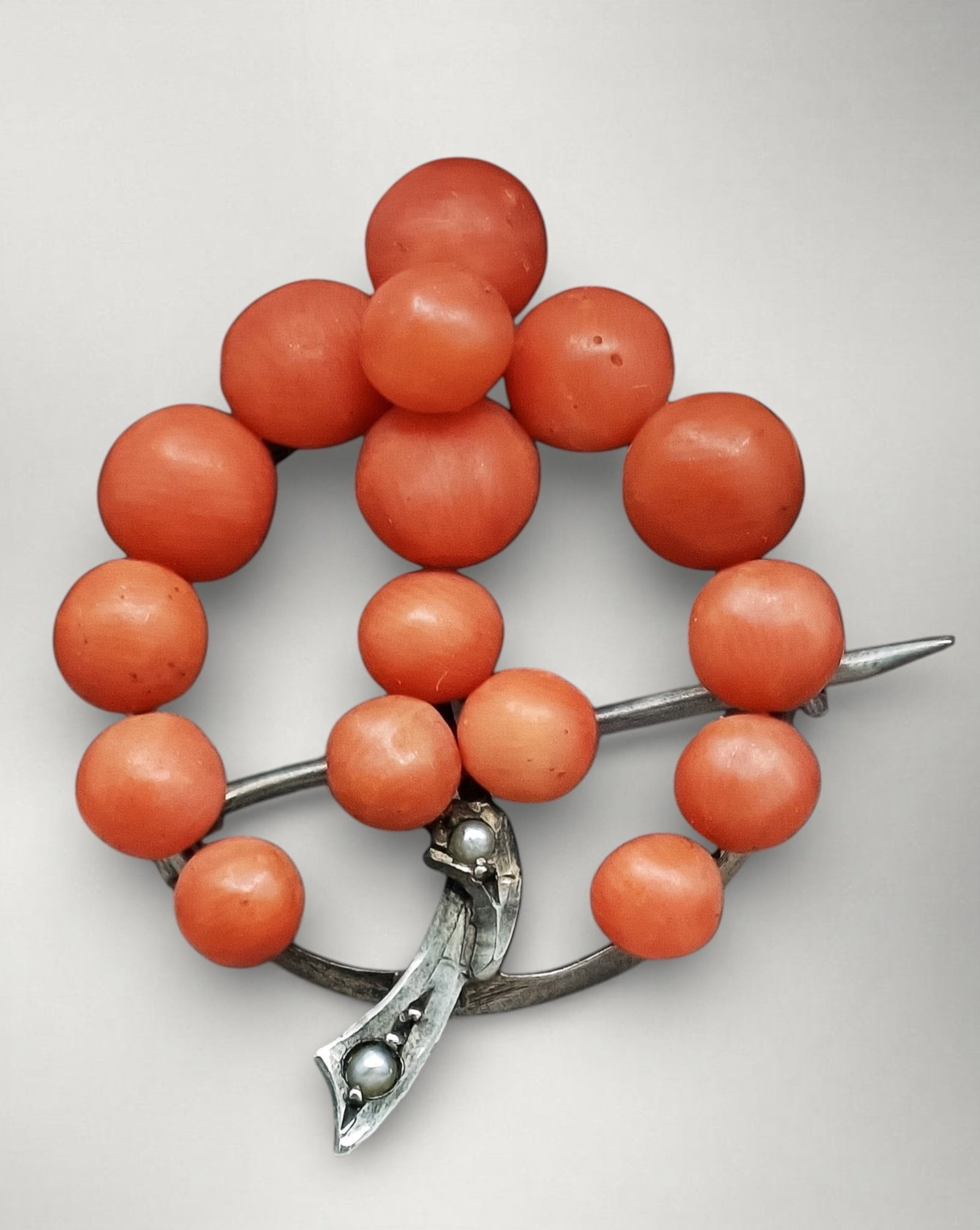Antique Biedermeier brooch with natural coral and silver setting: Natural salmon-red coral with a silver setting. Measures 3.4 x 2.8 cm. Antique Biedermeier-Art Nouveau brooch, circa 1900, composed of 18 untreated, beautiful salmon-red natural corals arranged in a b