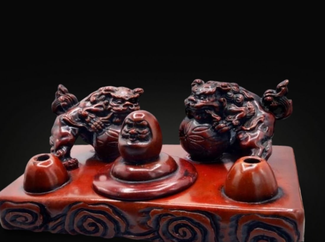 Oriental writing set with mythological figures and inkwell, 20th century. Weight: 1,080 g.: Reddish-hued stone with a lacquered finish, carved using sculptural techniques. Dimensions: 17 x 10 x 7 cm; weight: 1,080 g. This substantial and meticulously crafted oriental writing set features a r