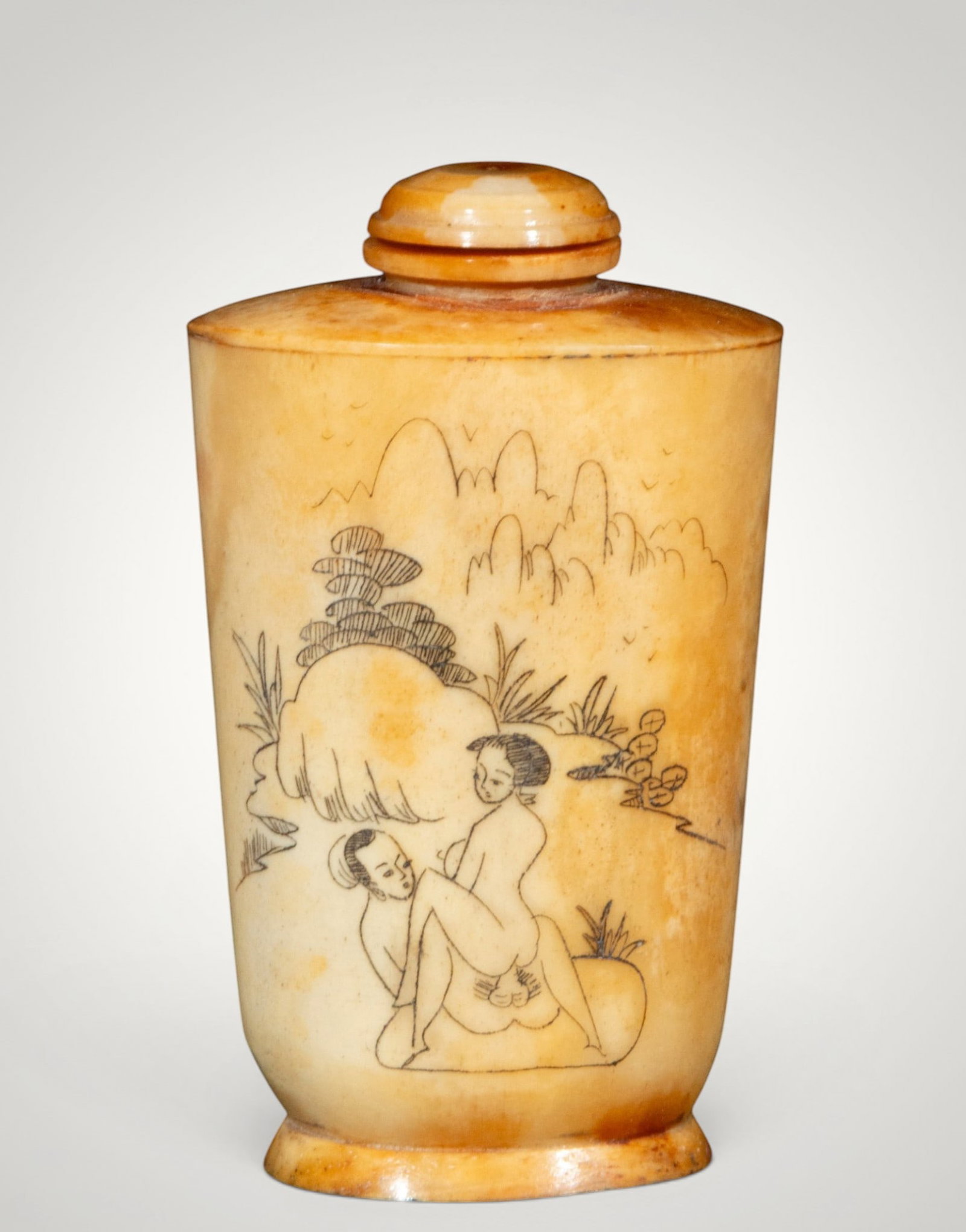 Snuff bottle with erotic scene. Japanese School. 19th century: Carved, polished, and incised bone. Measures 8 x 5 x 3 cm. Cylindrical bottle with a ringed base and circular stopper, decorated with an erotic scene set in a mountainous landscape of pines, rocks, an
