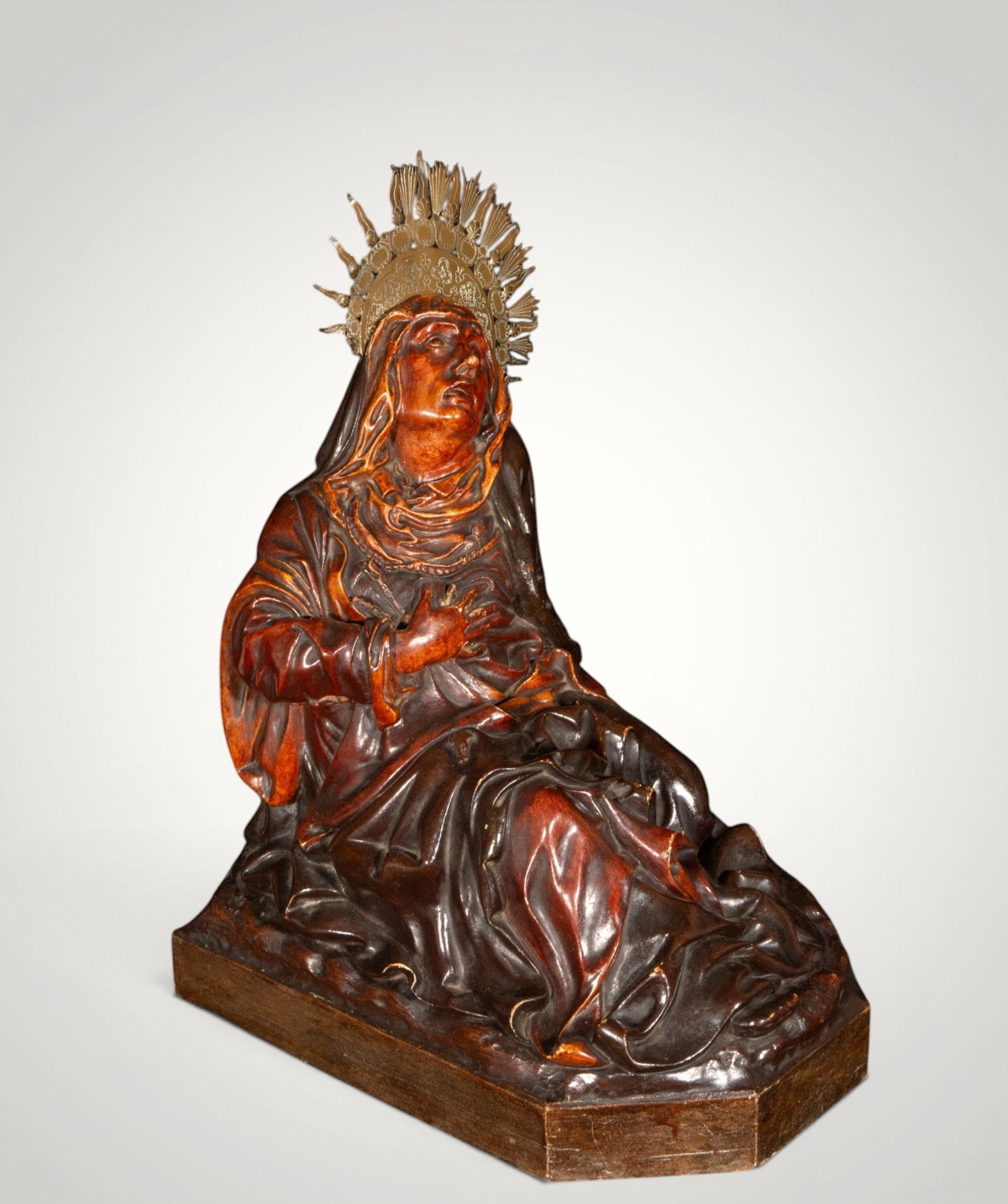 Our Lady of Sorrows. Spanish School. 19th Century: Wooden carving. Measures 54 x 20 x 40 cm. Image of the Virgin of Sorrows seated with an expression of profound contemplation, carved with ample folds and elegant modeling. It retains its metal crown a