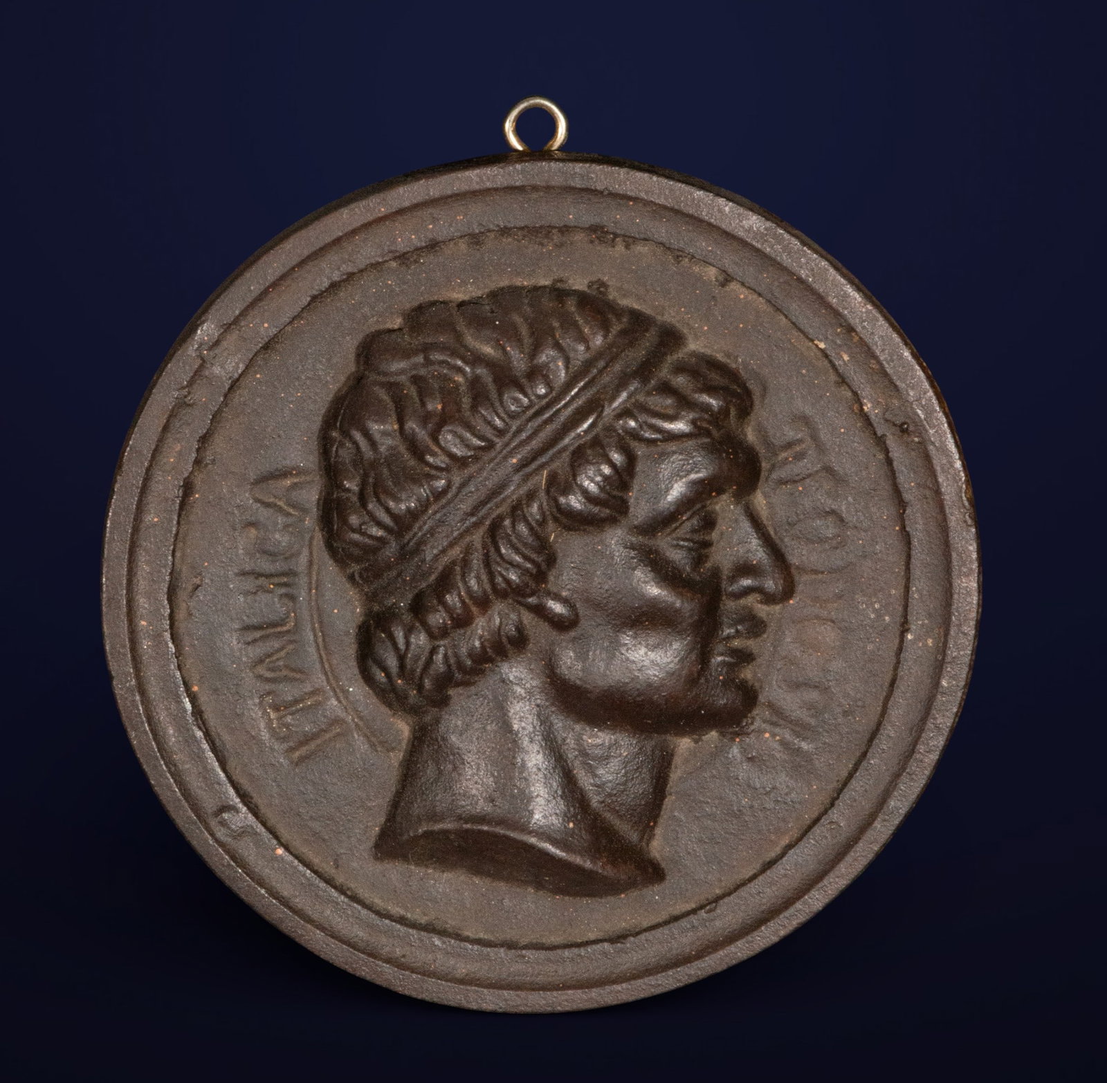Portrait of Emperor Theodosius in profile, Grand Tour School, 19th century: Cast iron. Measures 17 cm in diameter. Circular relief depicting the profile of Emperor Theodosius, inspired by numismatic models and portraits from Roman antiquity. The face is presented with idealiz