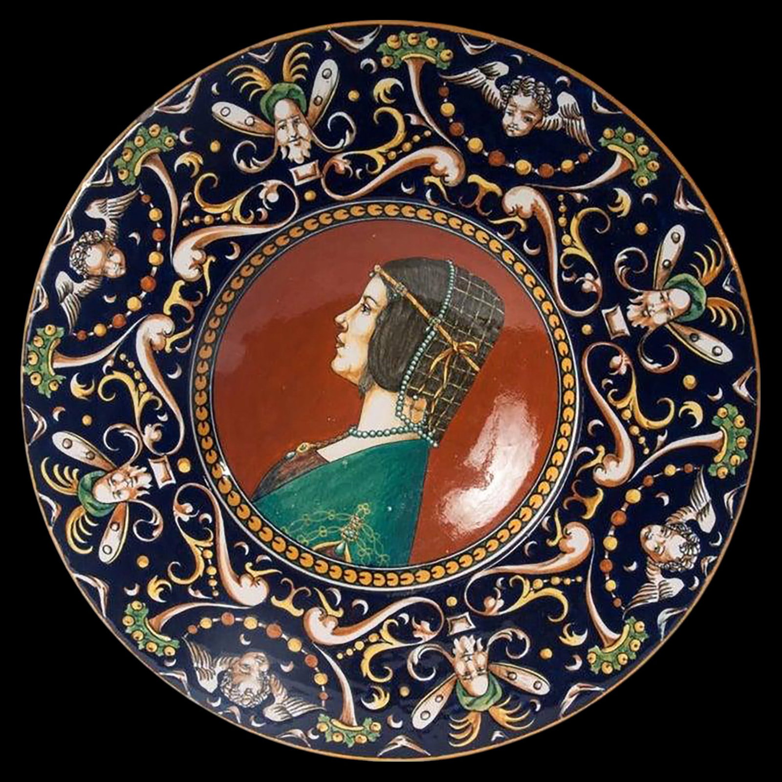 Important Plate Fratelli Minardi, Faenza, 1920: 43.5 x 5 cm. Profile of a lady, polychrome ceramic plate with a wide rim and deep recess, with an annular support on the back, on a recessed background. Stylized Raphaelesque decoration on a blue back