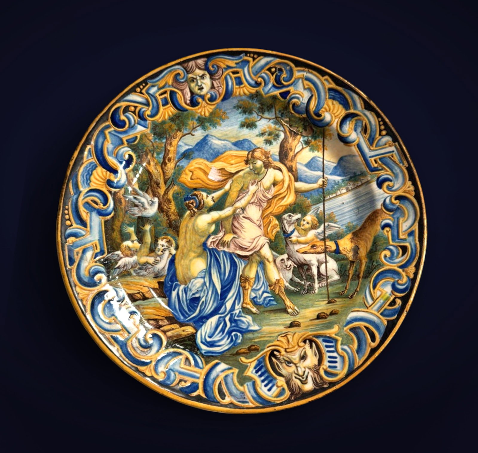 Beautiful 19th century Italian ceramic plate: Dish with a large fire decoration in the center of a mythological scene and on the side a frieze of interlacing, a mask, a grotesque, and shells. Diameter 33 cm State of conservation: good condition
