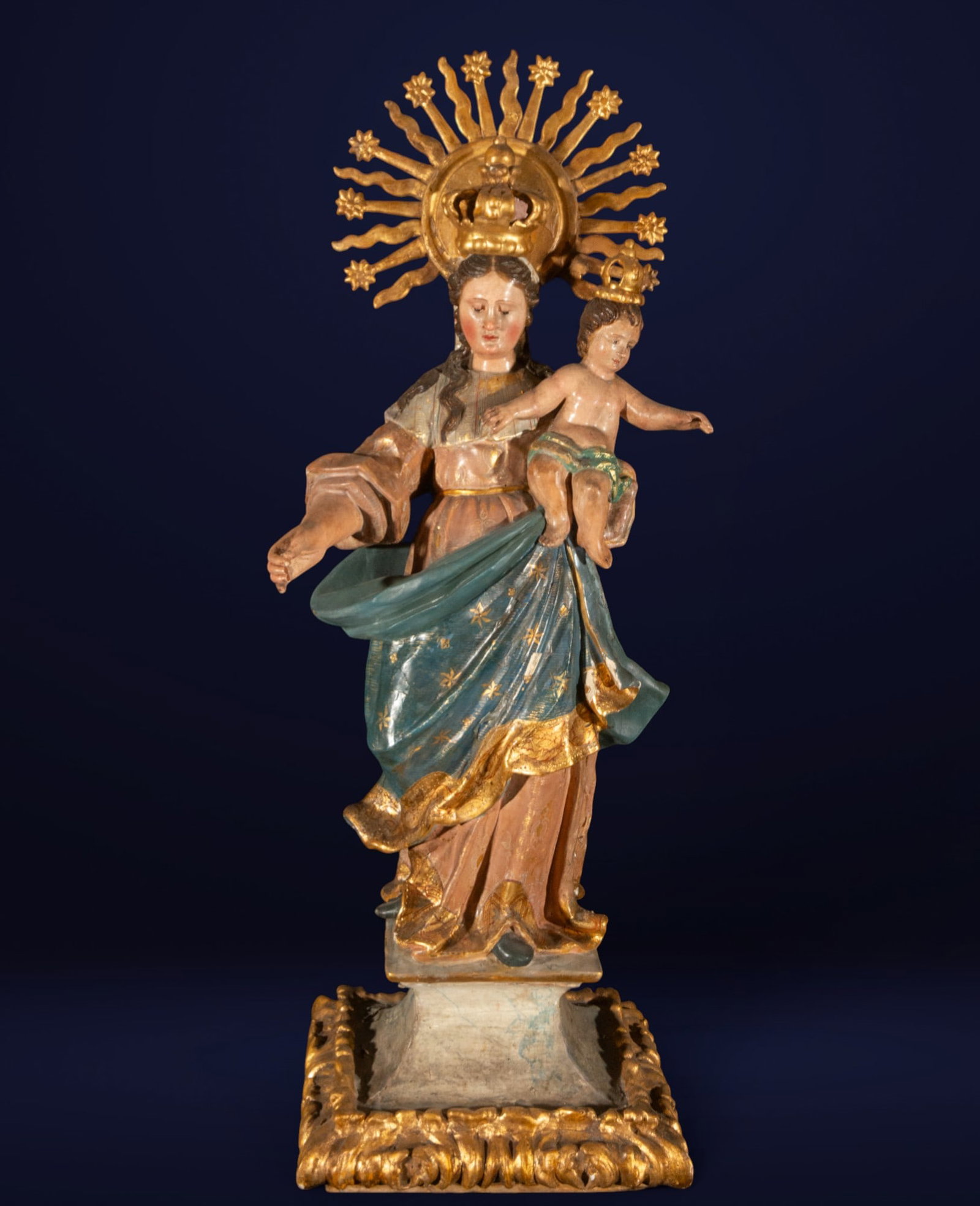 Virgin and Child. Spanish School. 18th Century: Polychrome wood carving. A religious sculpture in the round depicting the standing Virgin Mary holding the Child Jesus in her left arm. Both figures are crowned with raised golden radiance, highlighti