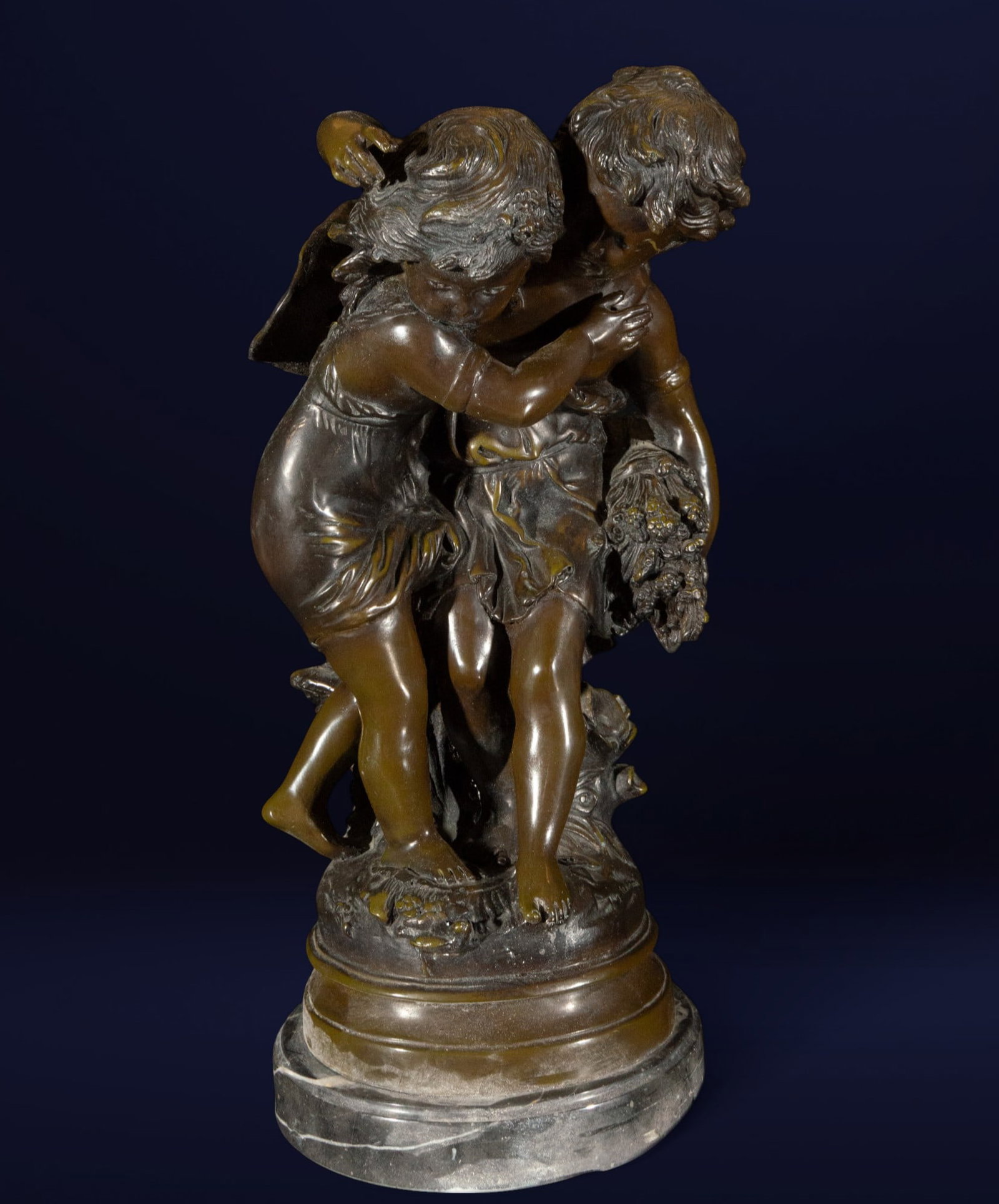 Bronze painting of children playing. French School. 19th century: Patinated bronze sculpture. A dynamically composed sculptural group depicting two children engaged in a playful game of chase or dance, captured with natural gestures and animated faces. The work conv